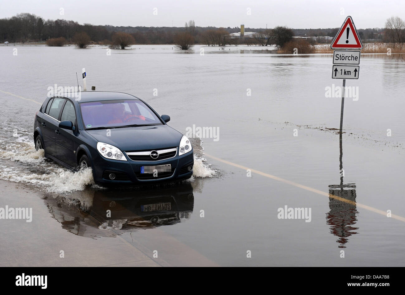 Ein Auto fährt entlang einer überfluteten Landstraße in der Nähe Eissel, Deutschland, 12. Januar 2011. Tauwetter verursachte Überschwemmungen in mehreren Regionen Deutschlands. Foto: Ingo Wagner Stockfoto
