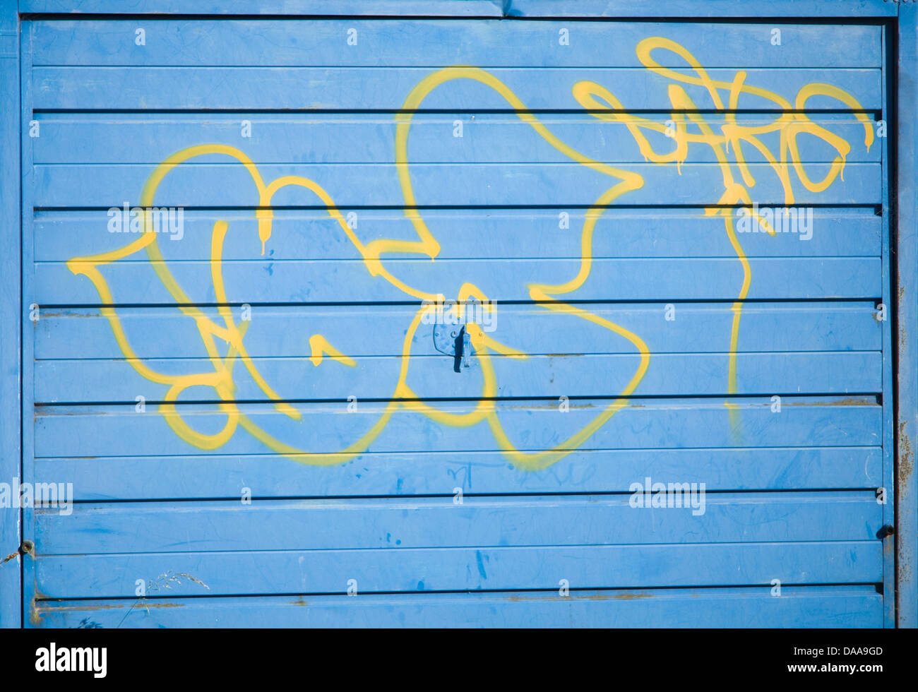 Graffiti auf blaue Garagentor gespritzt Stockfotografie - Alamy