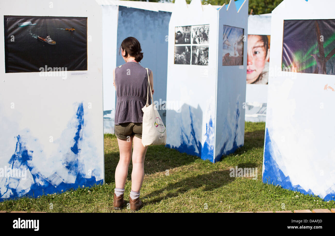 Eine Frau schaut eine Fotoausstellung in der Greenpeace-Dorf am Glastonbury Festival 2013 Stockfoto