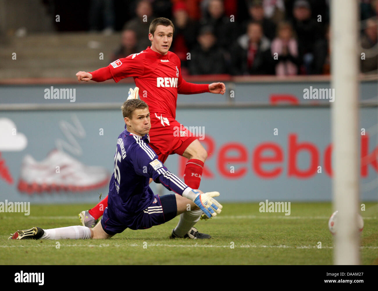 Kölns Christian Clemens (L) wetteifert um den Ball mit der Münchner Goakeeper Thomas Kraft und erzielt das 2: 1 Tor während der Bundesliga-Fußballspiel zwischen 1. FC Köln und FC Bayern München in der Publikumseingänge in Köln, Deutschland, 5. Februar 2011. Foto: Rolf Vennenbernd Stockfoto