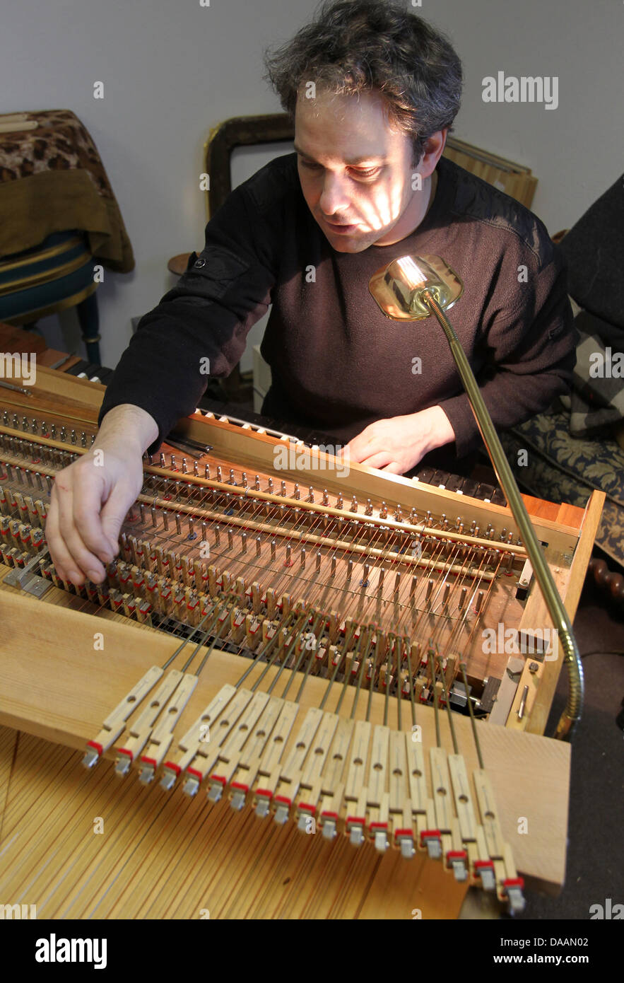 Orgelbauer und Restaurator Johann-Gottfried Schmidt arbeitet auf ein Cembalo aus dem Jahr 1970 in Rostock, Deutschland, 8. Februar 2011. Schmidt läuft seit sieben Jahren eine Werkstatt für historische Tasteninstrumente, er arbeitet hauptsächlich mit Zimbal und Organe. Foto: Bernd Wuestneck Stockfoto