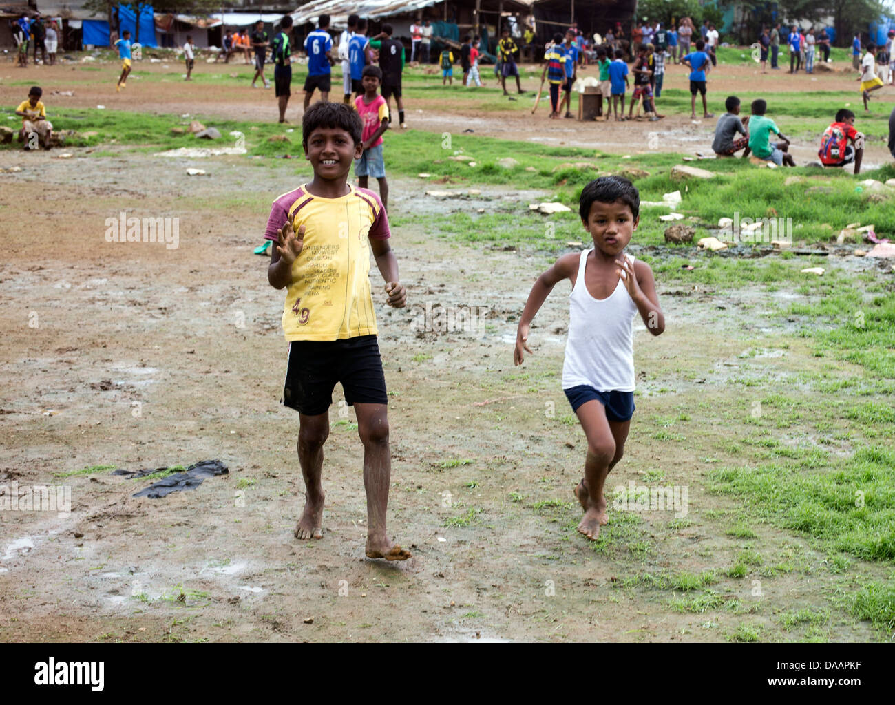 Mumbai-Fischer und ihre Kinder spielen Cricket während der Monsun-Wetter sie hält Angeln auf Brachland hinter Slums. Stockfoto