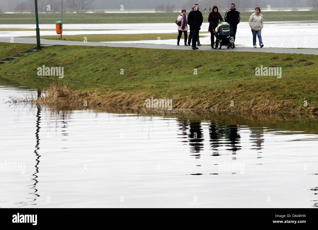 Die Menschen gehen auf eine Elbe-Deich in Doemitz, Deutschland, 23. Januar 2011. Die Elbe-Flut erreicht ihren Höhepunkt an diesem Wochenende in Mecklenburg Vorpommern. Der Wasserstand der Elbe in Doemitz war in der Nacht von 22 bis 23 Januar 6,72 m. D. h. 8 cm mehr als der Rekord des Jahres 2006 war die auf 6,64 Meter. Foto: Jens Büttner Stockfoto