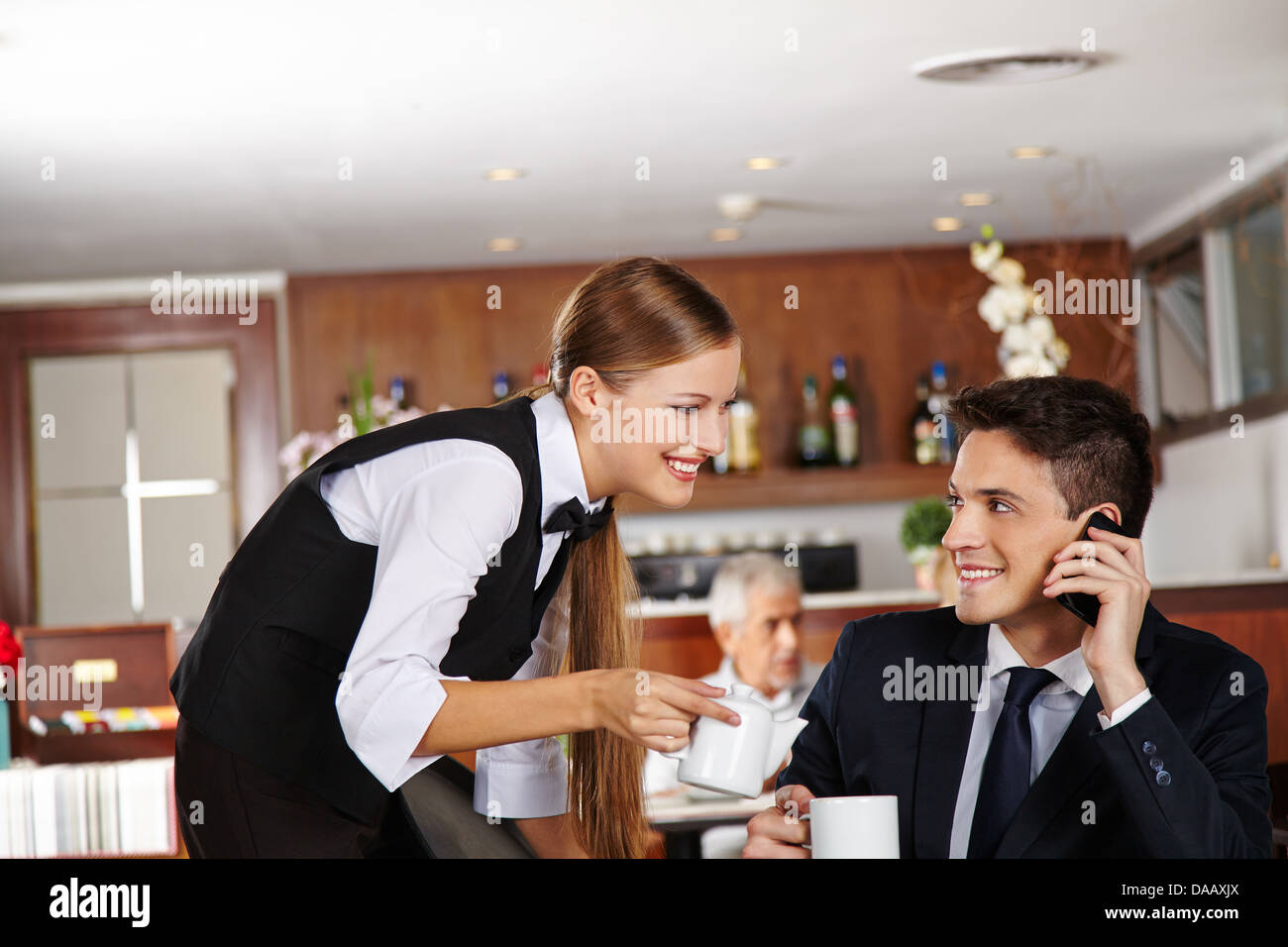 Kellner Geschäftsmann im Hotel Café eine Kanne Kaffee anzubieten Stockfoto