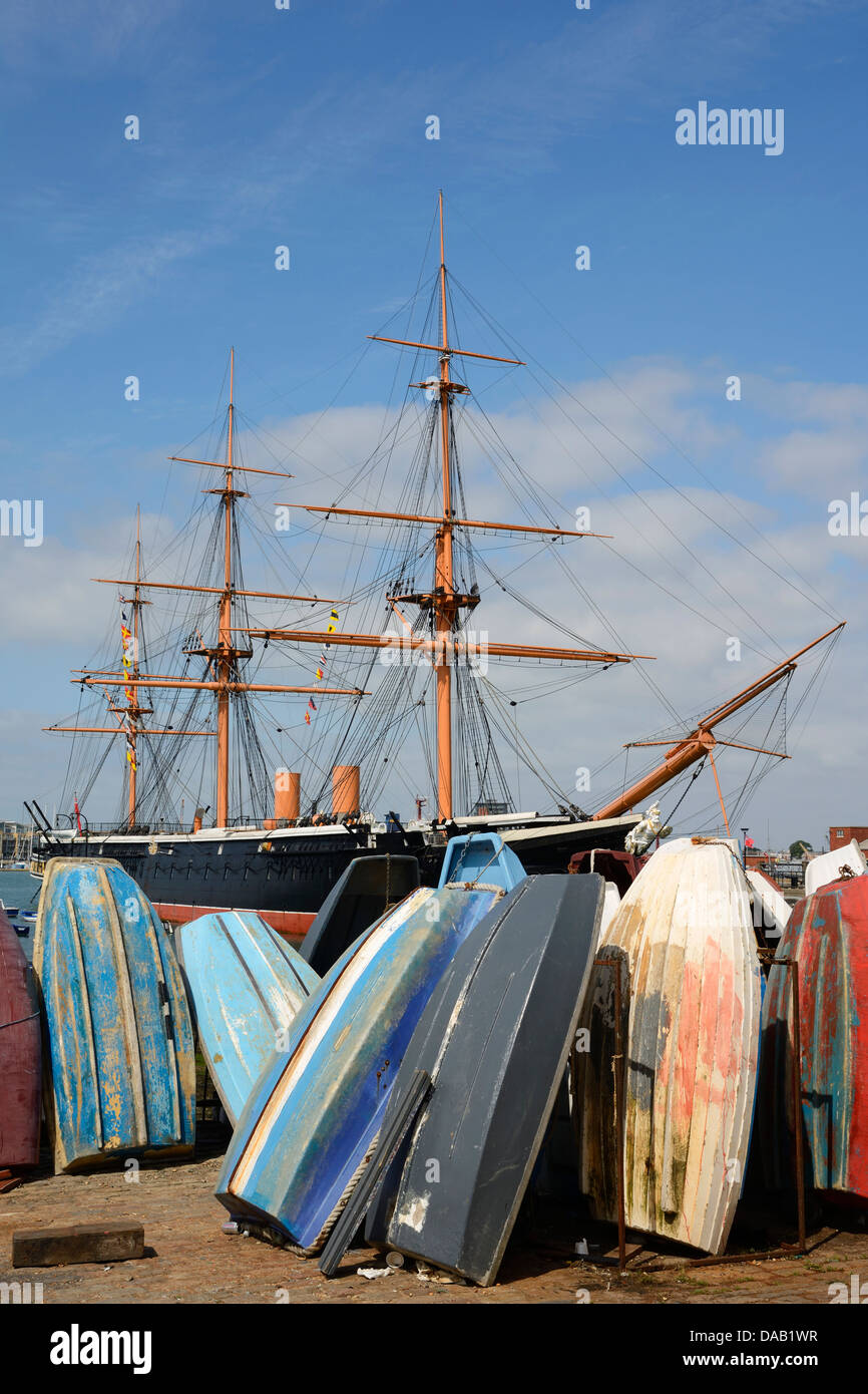 Hochkant kleine Boote mit HMS Krieger hinter bei der Historic Dockyard in Portsmouth Harbour, Hampshire, England, UK. Stockfoto