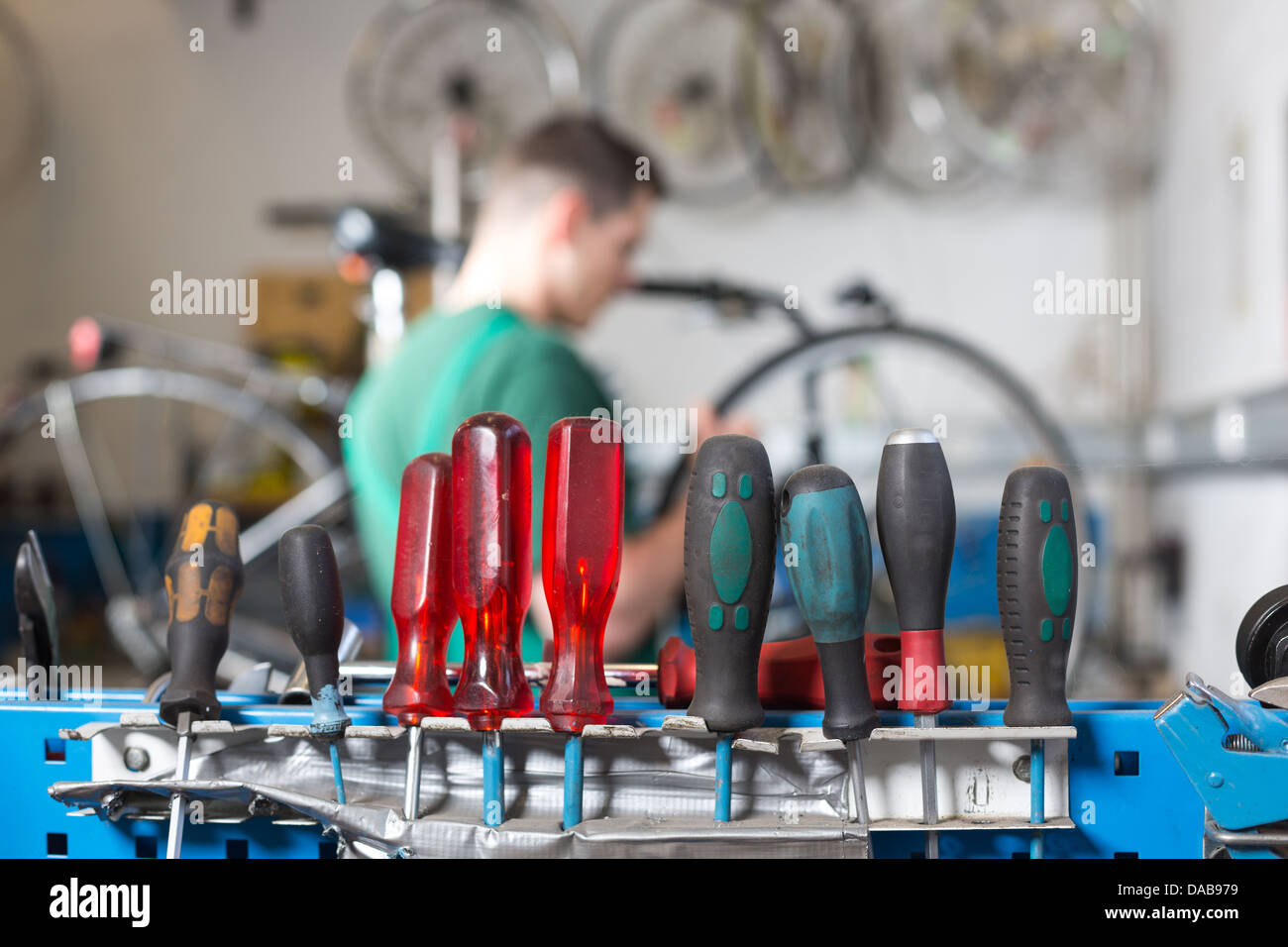 Werkzeuge in einem Workshop mit Fahrradmechaniker reparieren ein Rad im Hintergrund Stockfoto