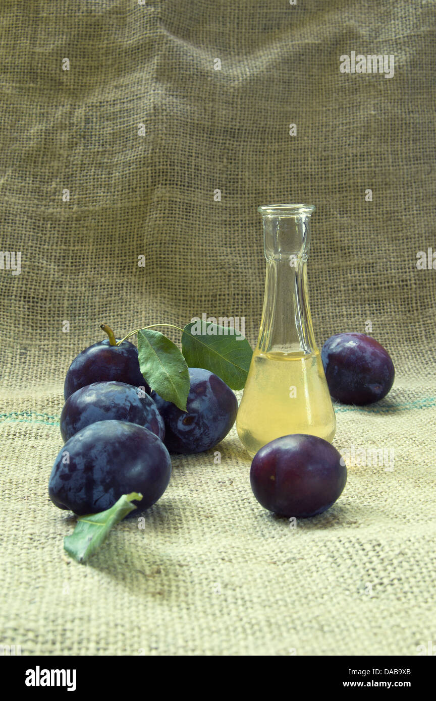 Pflaumen Schnaps mit frischen und schmackhaften Pflaume Frucht auf einer Tischdecke. Stockfoto