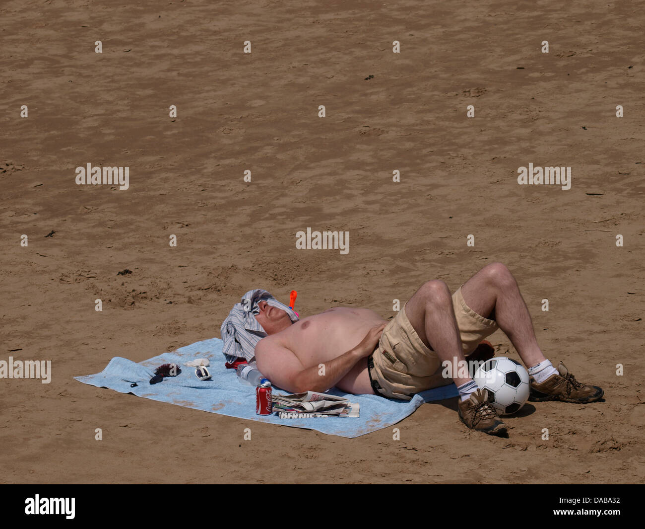 Mann, Sonnenbaden am Strand, Burnham auf Meer, Somerset, UK 2013 Stockfoto