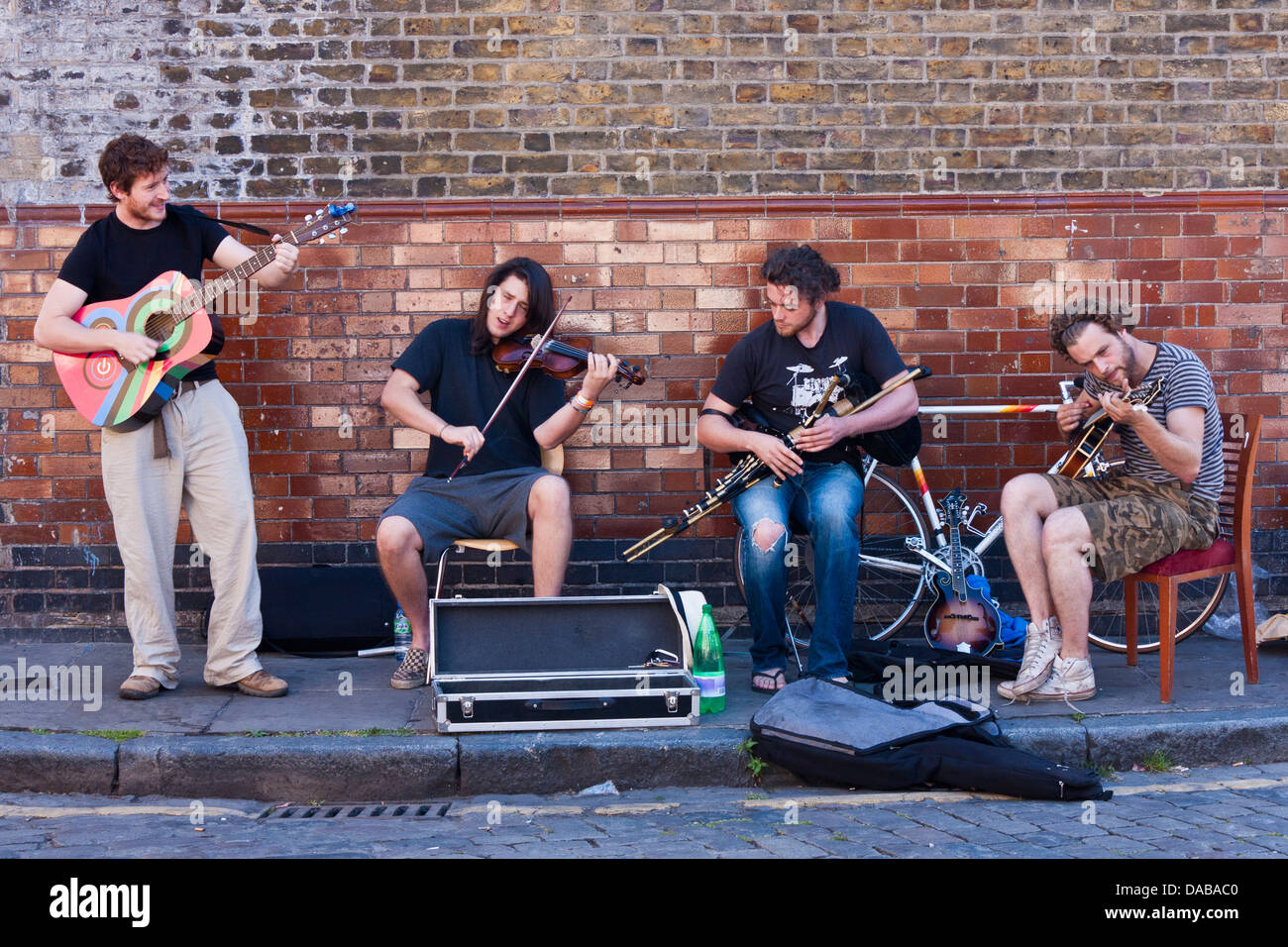 Eine Bande von jungen Straßenmusiker führen auf den Straßen von London an der Columbia Road Flower Markt, London, England, GB, UK. Stockfoto