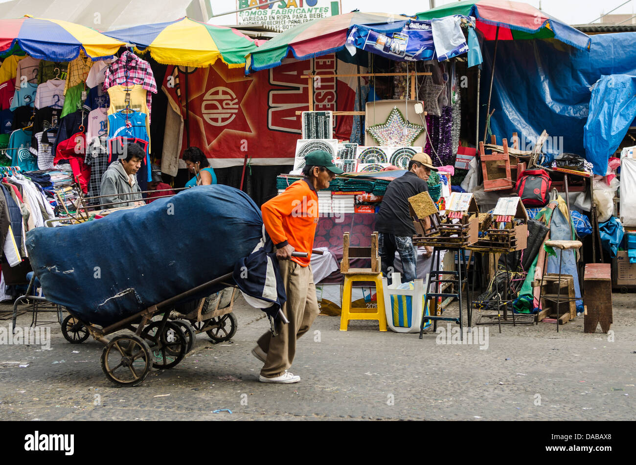 Man zieht Warenkorb Bekleidungsgeschäfte Ständen Einkaufen in lokalen Zentralmarkt Marktplatz in Chiclayo, Peru. Stockfoto