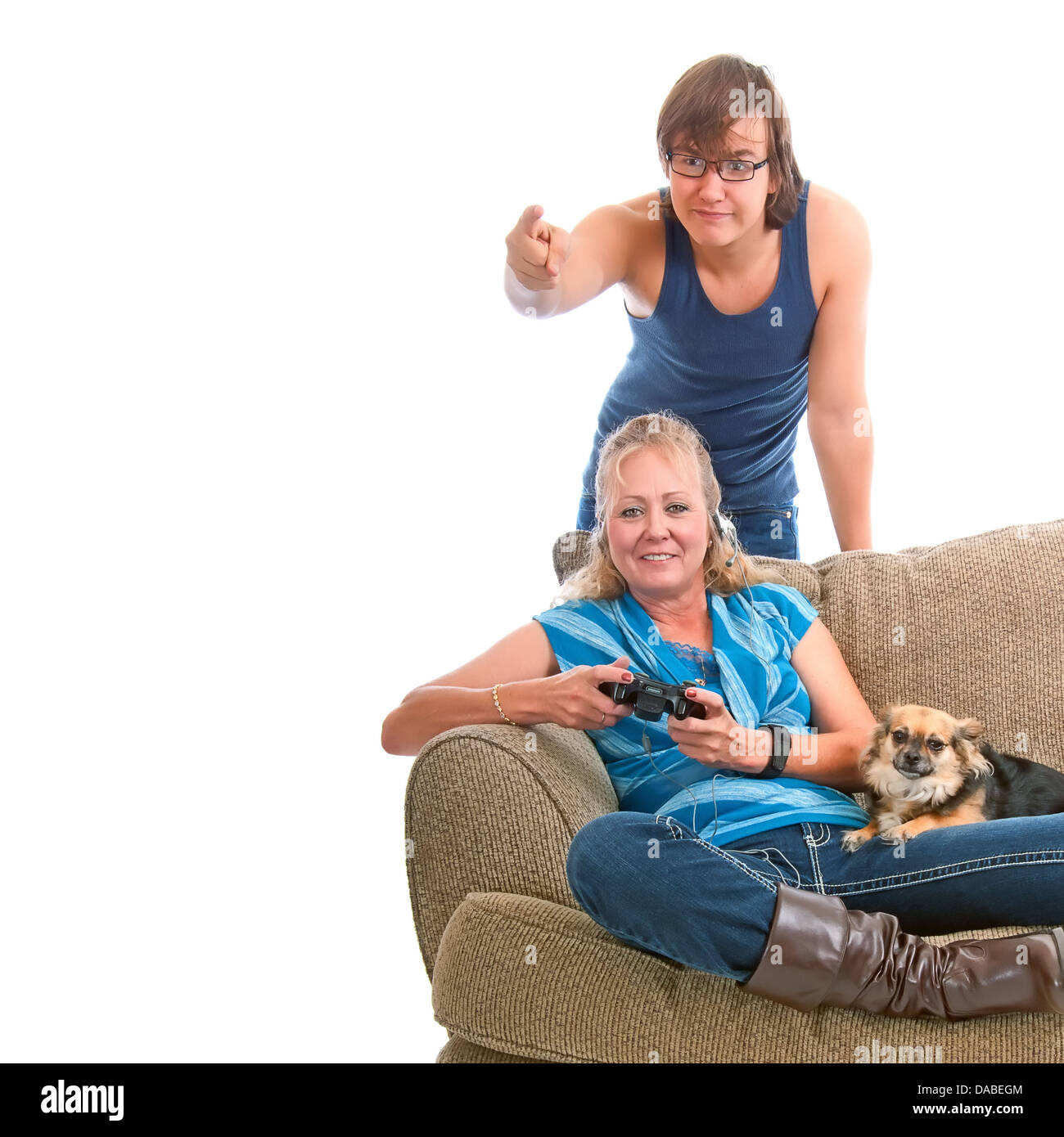 Blonde Frau mit Hund auf dem Schoß, lernen, mit ihrem Sohn hinter der Couch coaching Videospiel zu spielen. Stockfoto