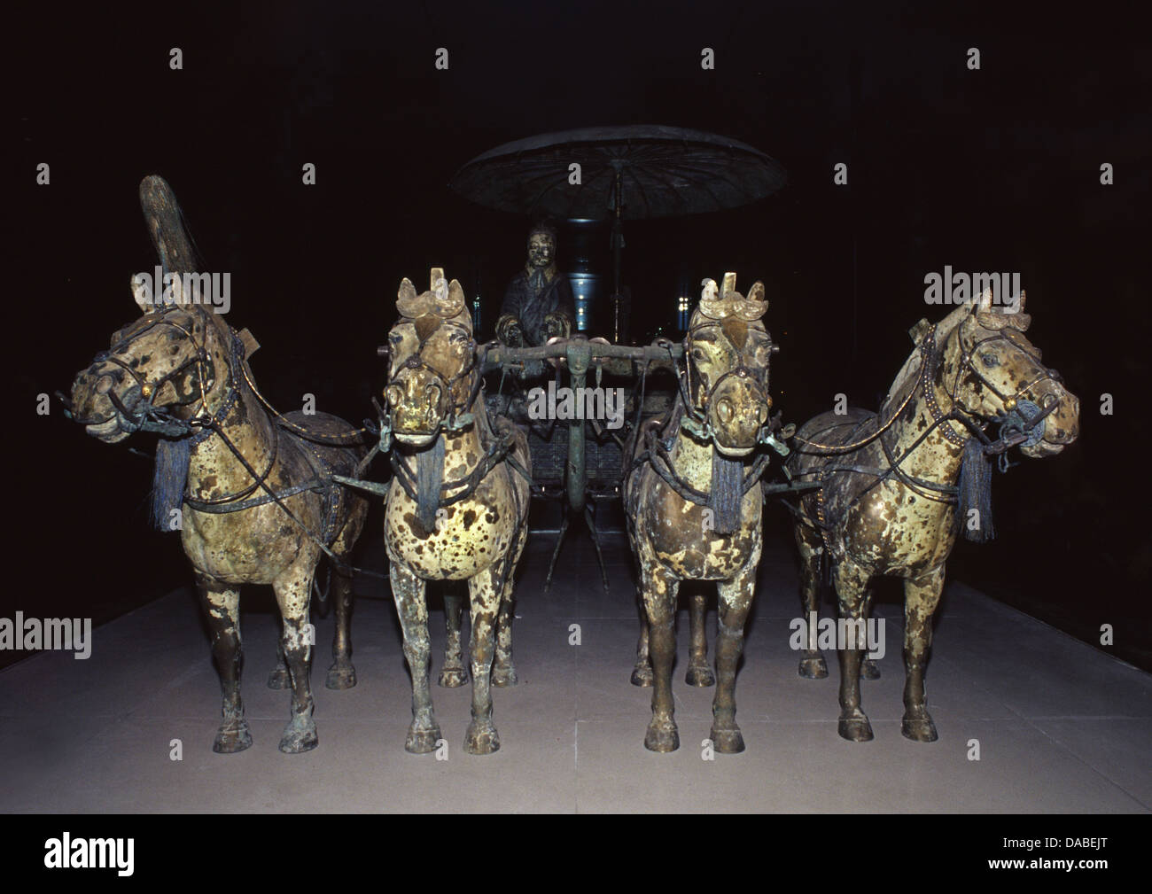 Der Qin-dynastie bronze Modell chariot durch vier Bronzene Pferde gezogen, mit einem einzigen stehenden Fahrer und eine Bronze Regenschirm auf einem Ständer platziert neben ihm im Museum der Terracotta Krieger und Pferde von Qin Shi Huang in Lintong Bezirk in Xi'an, die Hauptstadt der Provinz Shaanxi, China gespeichert Stockfoto