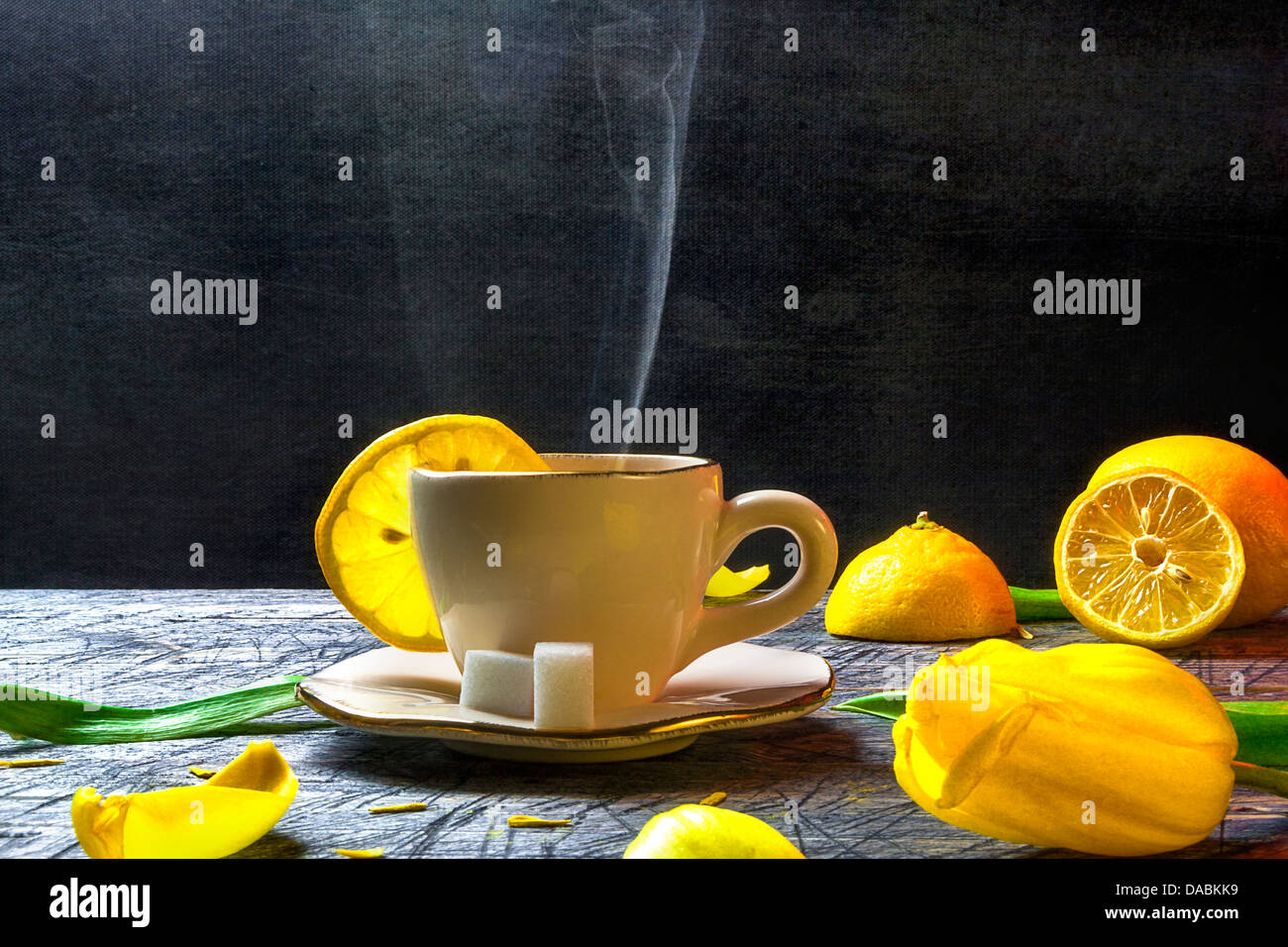 Tasse heißen Tee und Zitronen auf Holzbrett Stockfoto