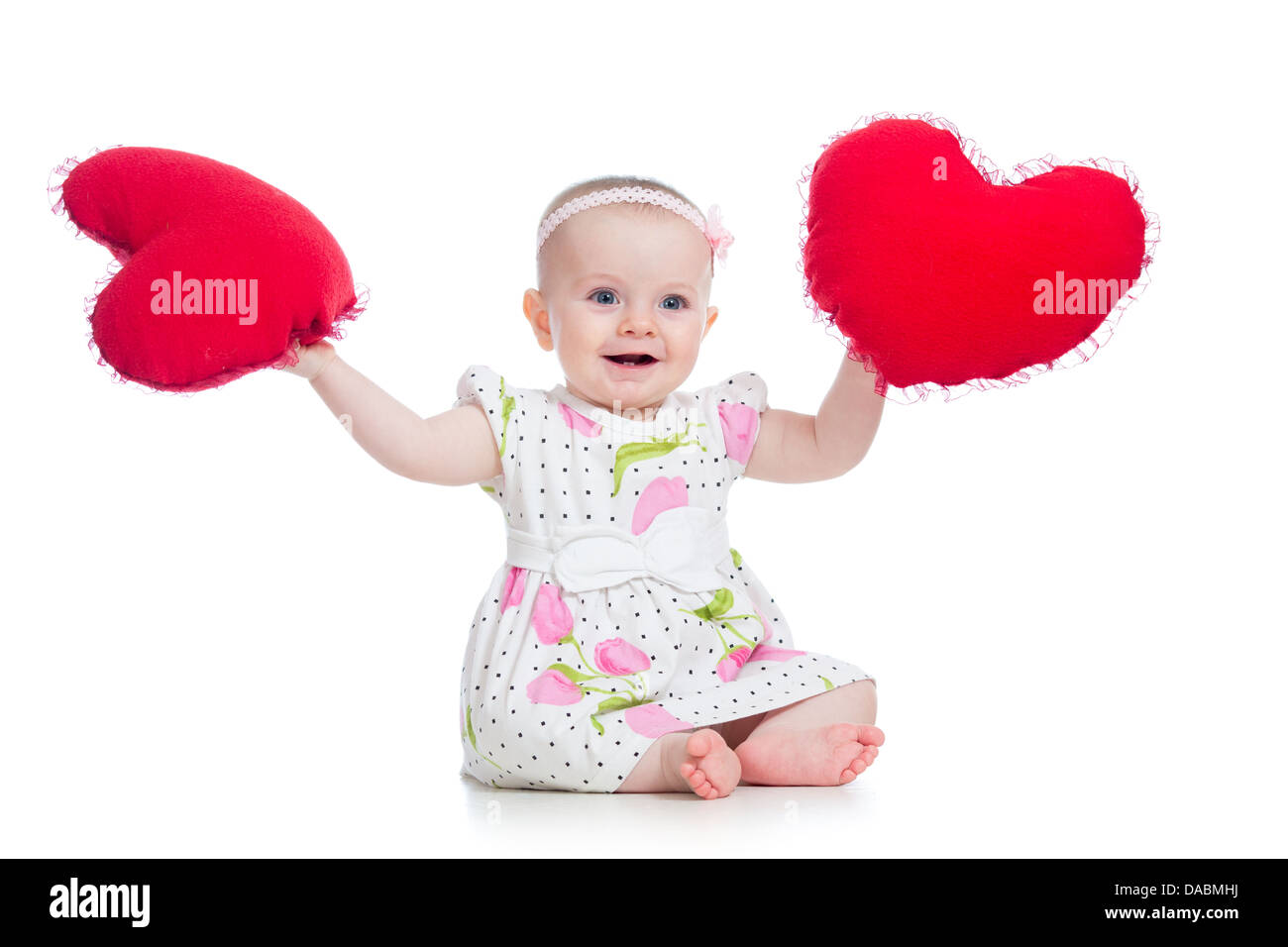 Babymädchen mit Kissen in Herzform Stockfoto