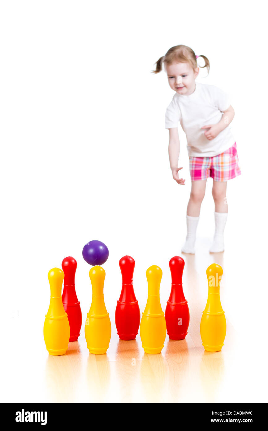Kind Mädchen wirft Ball Spielzeug bowling-Pins abzureißen. Kegeln im Mittelpunkt. Stockfoto