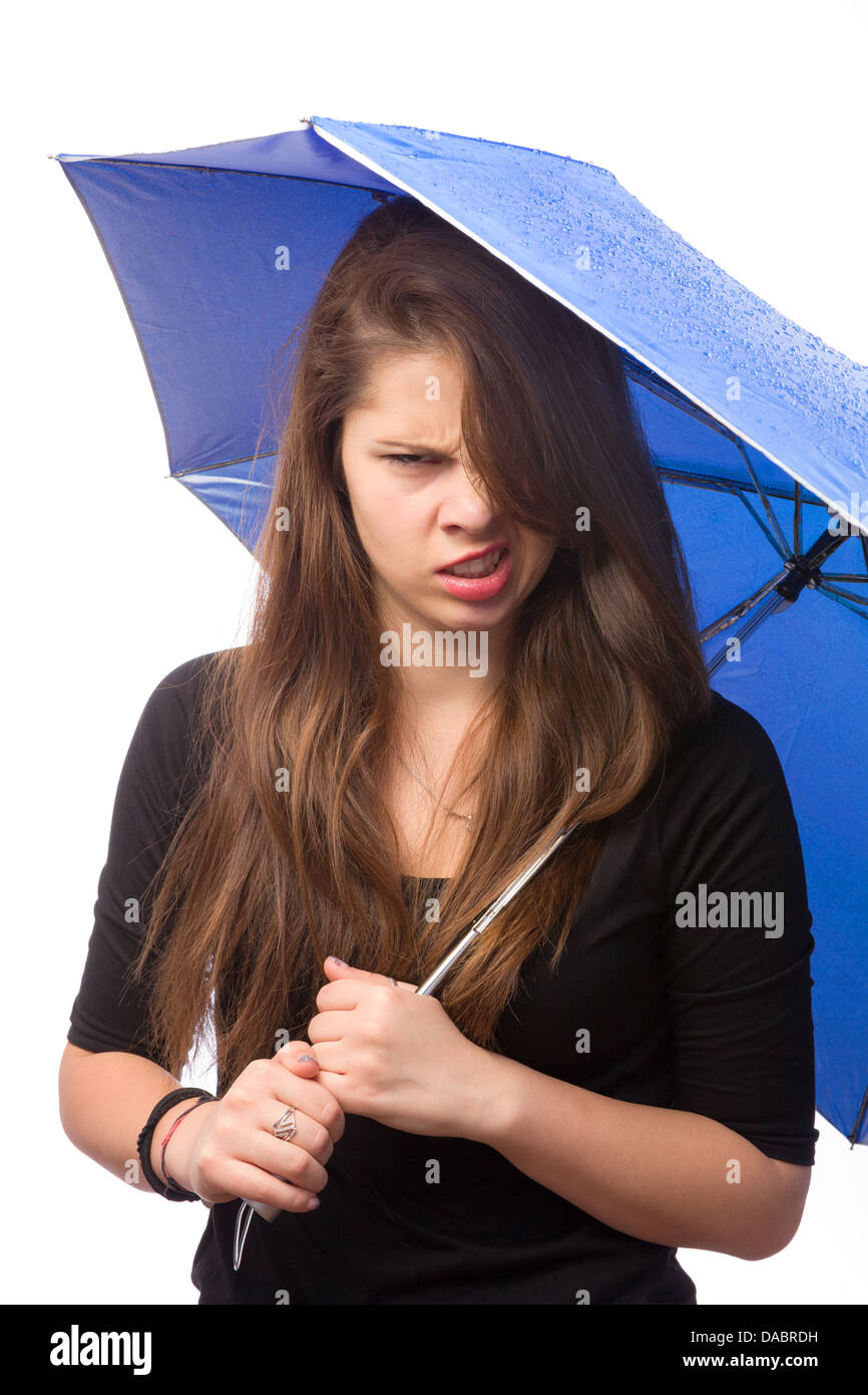 Böse Mädchen hält einen nassen Regenschirm mit Regen fällt Stockfoto