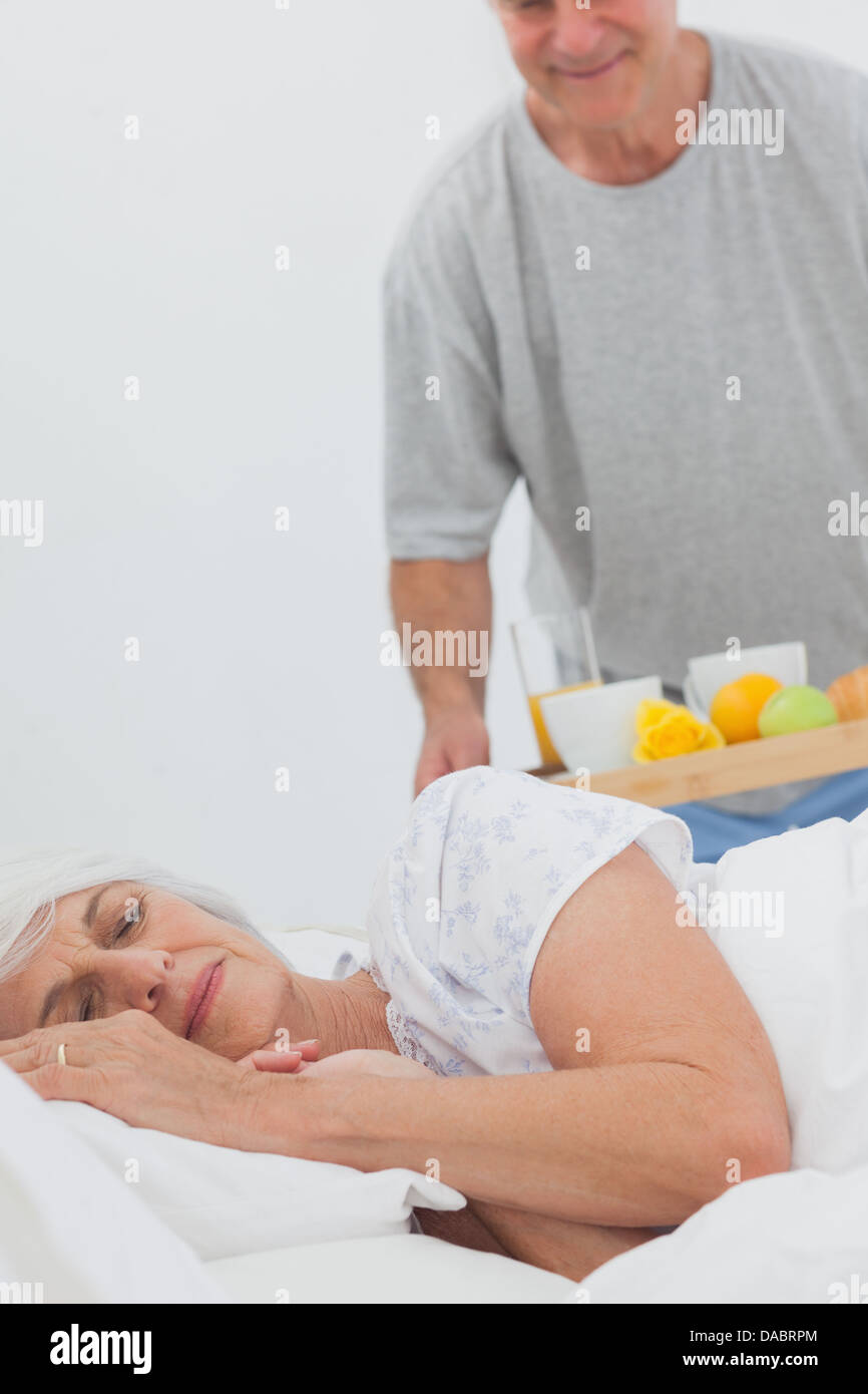 Mann bringen schlafende Frau Frühstück im Bett Stockfoto