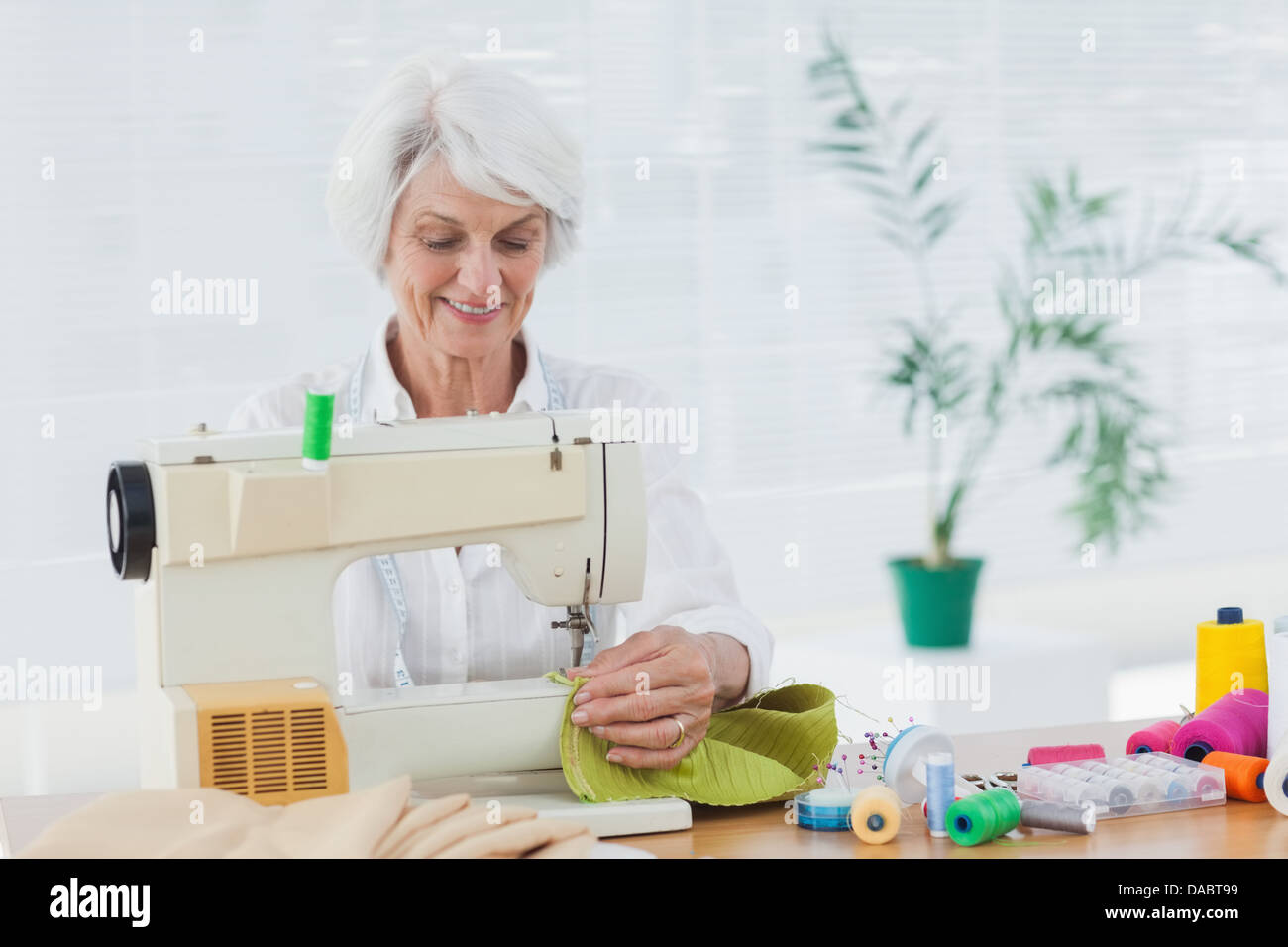 Pensionierte Frau, mit der Nähmaschine Stockfoto