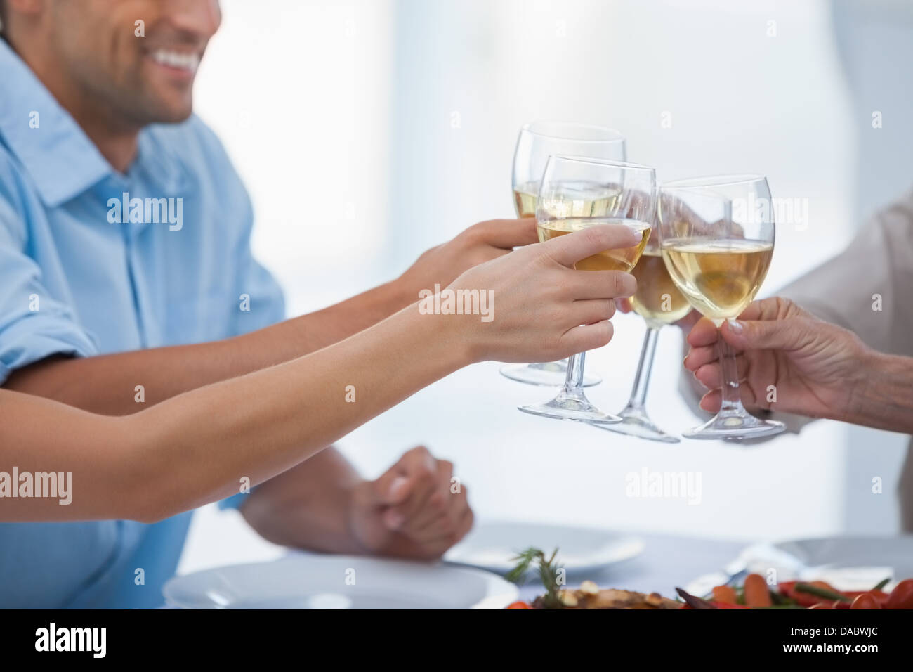 Nahaufnahme von Händen klirrende Gläser Weißwein Stockfoto