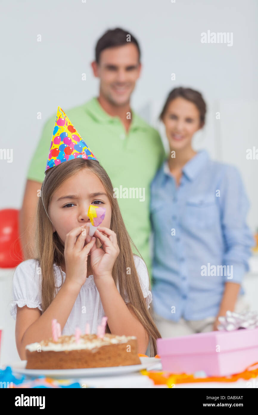 Kleine Mädchen spielen mit einem Party-horn Stockfoto