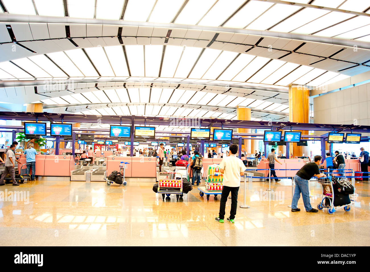 Menschen beim Check-in Schalter am Changi International Airport. Stockfoto