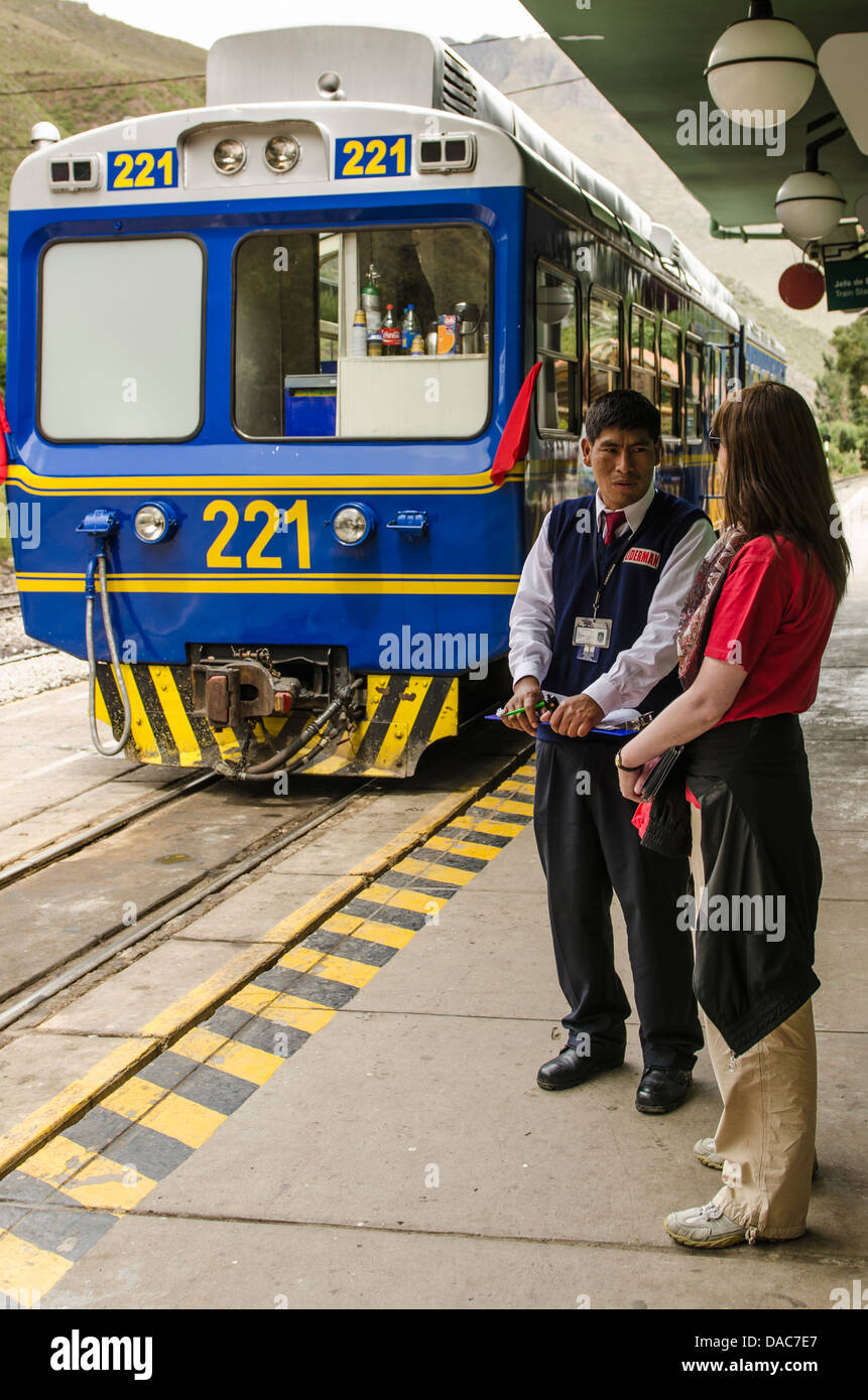 Passagier touristische Gespräche zu Perurail Zugpersonal auf der Plattform am Bahnhof in Ollantaytambo Ollantaytambo, Sacred Valley, Peru. Stockfoto