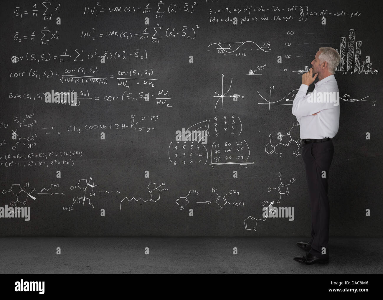 Elegante Geschäftsmann Blick auf Mathe-Gleichungen Stockfoto