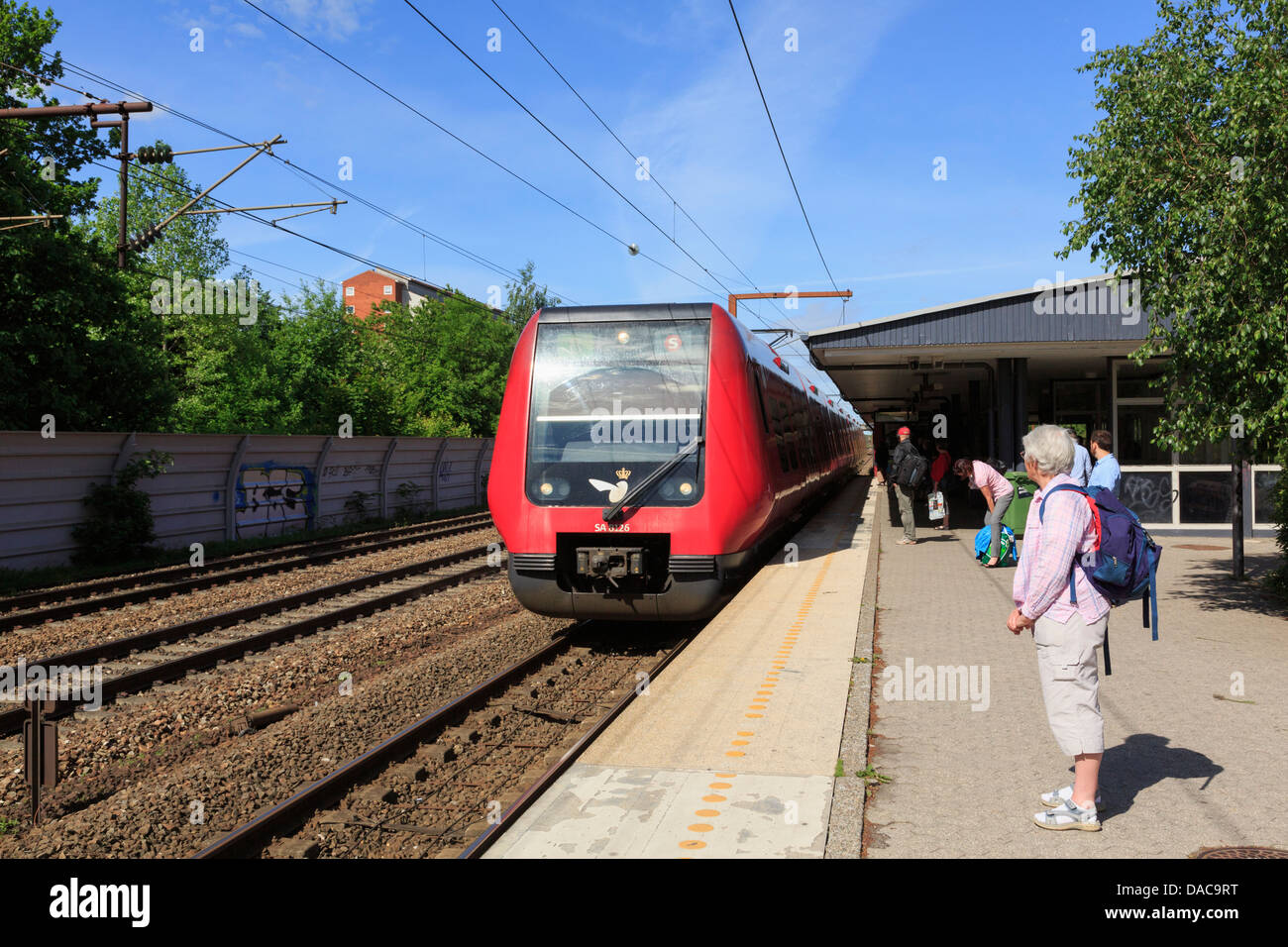 Passagiere warten auf Plattform mit S Bahn Ankunft in Brondbyoster Railway Station, Großraum Kopenhagen, Seeland, Dänemark Stockfoto