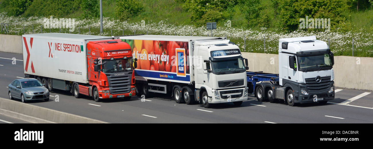 Drei Lastwagen und ein Auto überholen auf einer vierspurigen Abschnitt der Autobahn M25 London Orbital Stockfoto