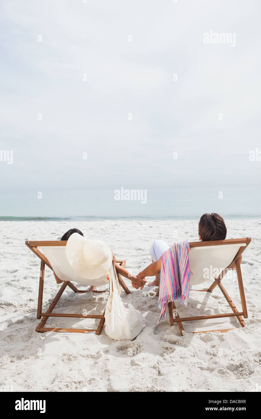 Paar sucht Ozean auf ihren Liegestühlen Stockfoto