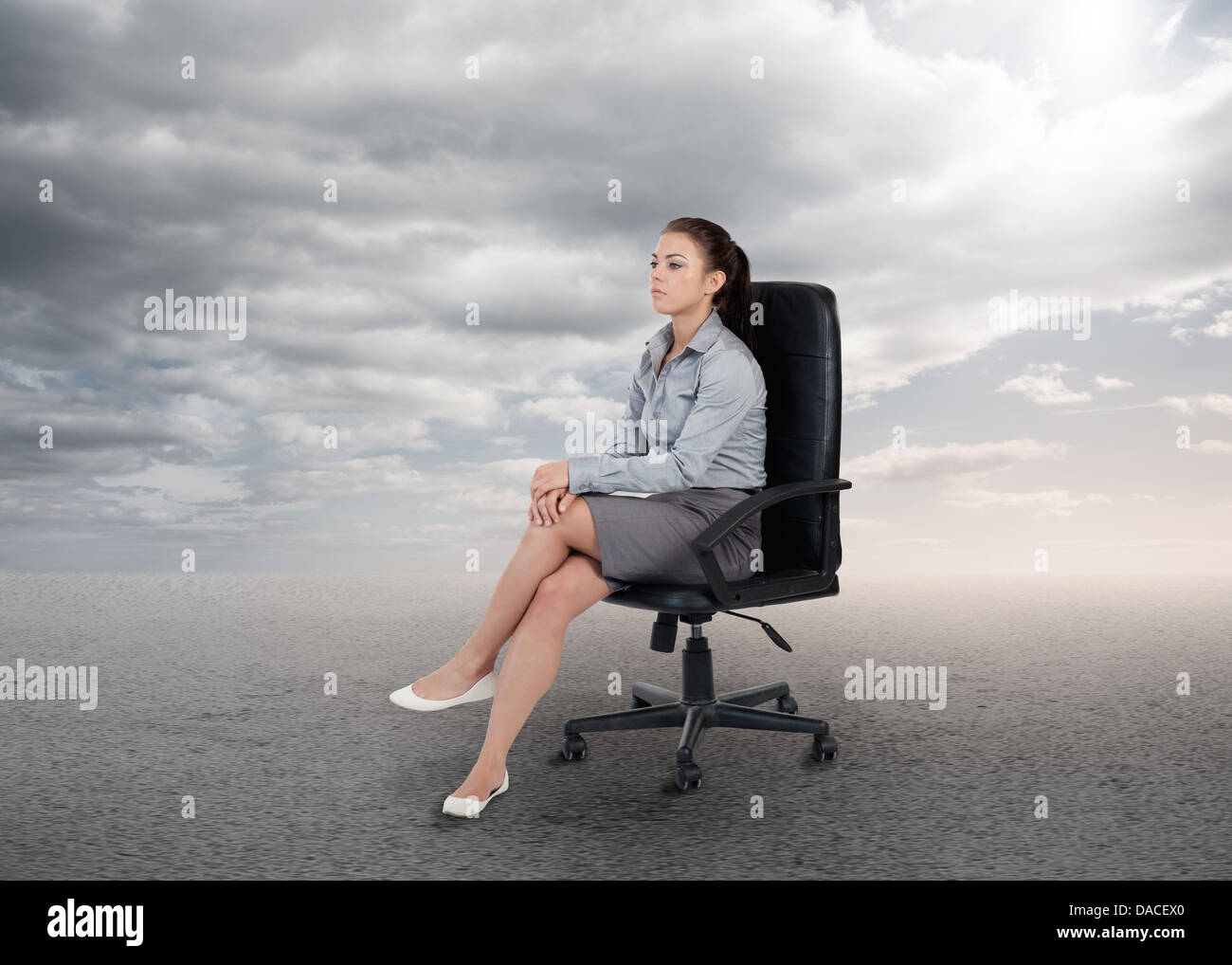 Attraktive Geschäftsfrau, die auf einem Stuhl sitzend Stockfoto