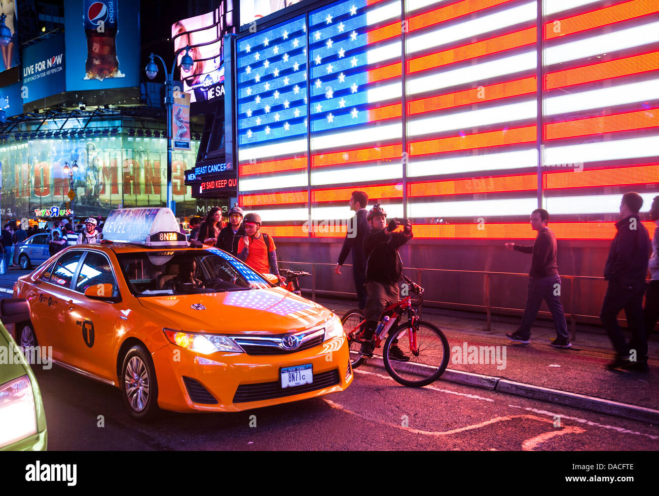 Beleuchtete Stars And Stripes Flagge mit Taxi, Times Square, Manhattan, NYC, USA. Stockfoto