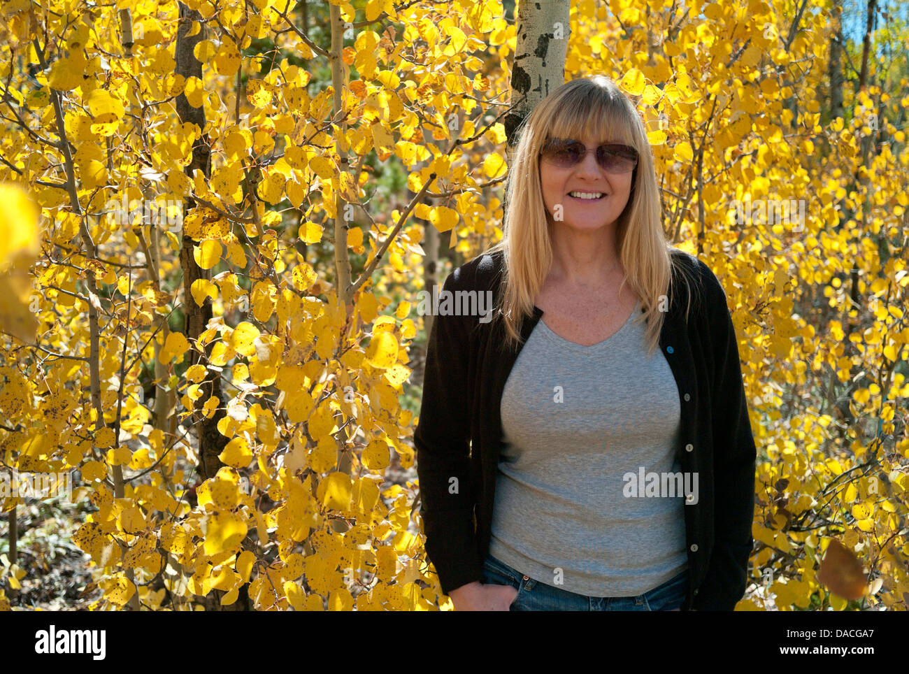 Frau an einem Aspen Baum gelehnt. Stockfoto