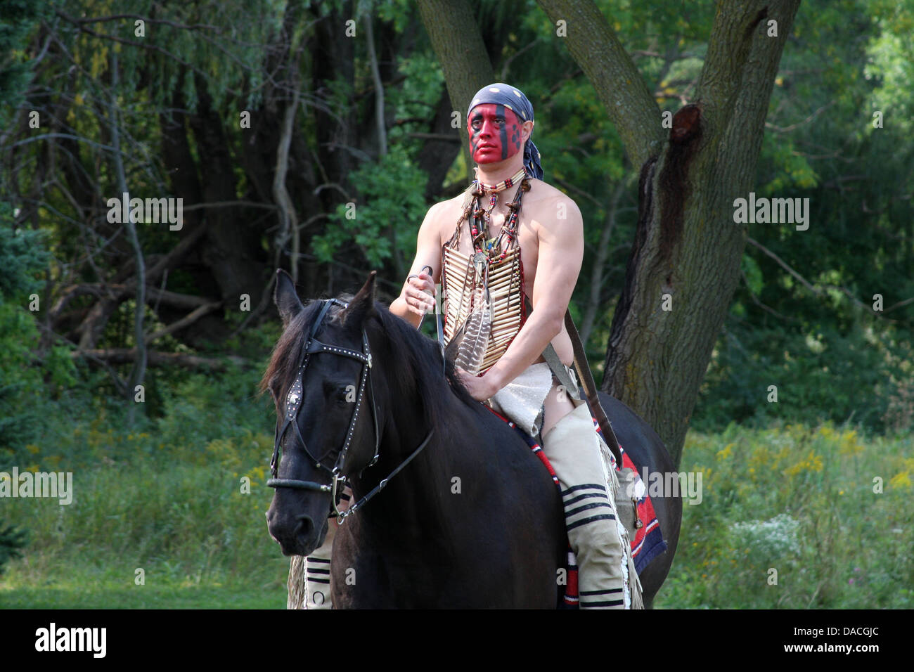 Native American Indian Mann auf dem Pferderücken Stockfoto