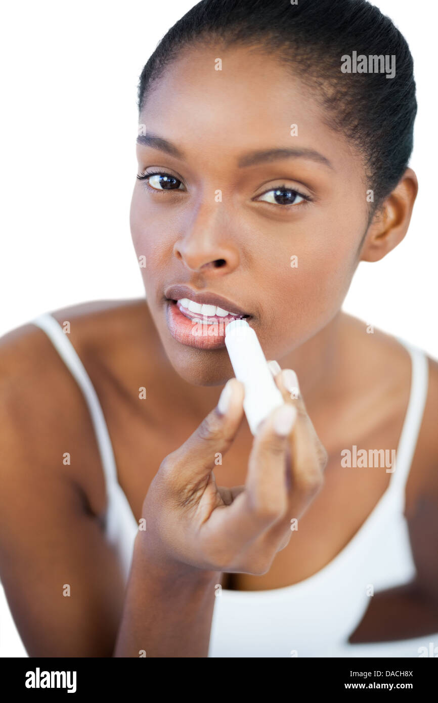 Hübsche Frau, die ihre Lippen Lippenbalsam aufsetzen Stockfoto