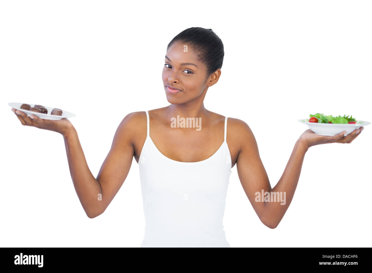 Hübsche Frau, die Entscheidung zu essen gesund oder nicht Stockfoto