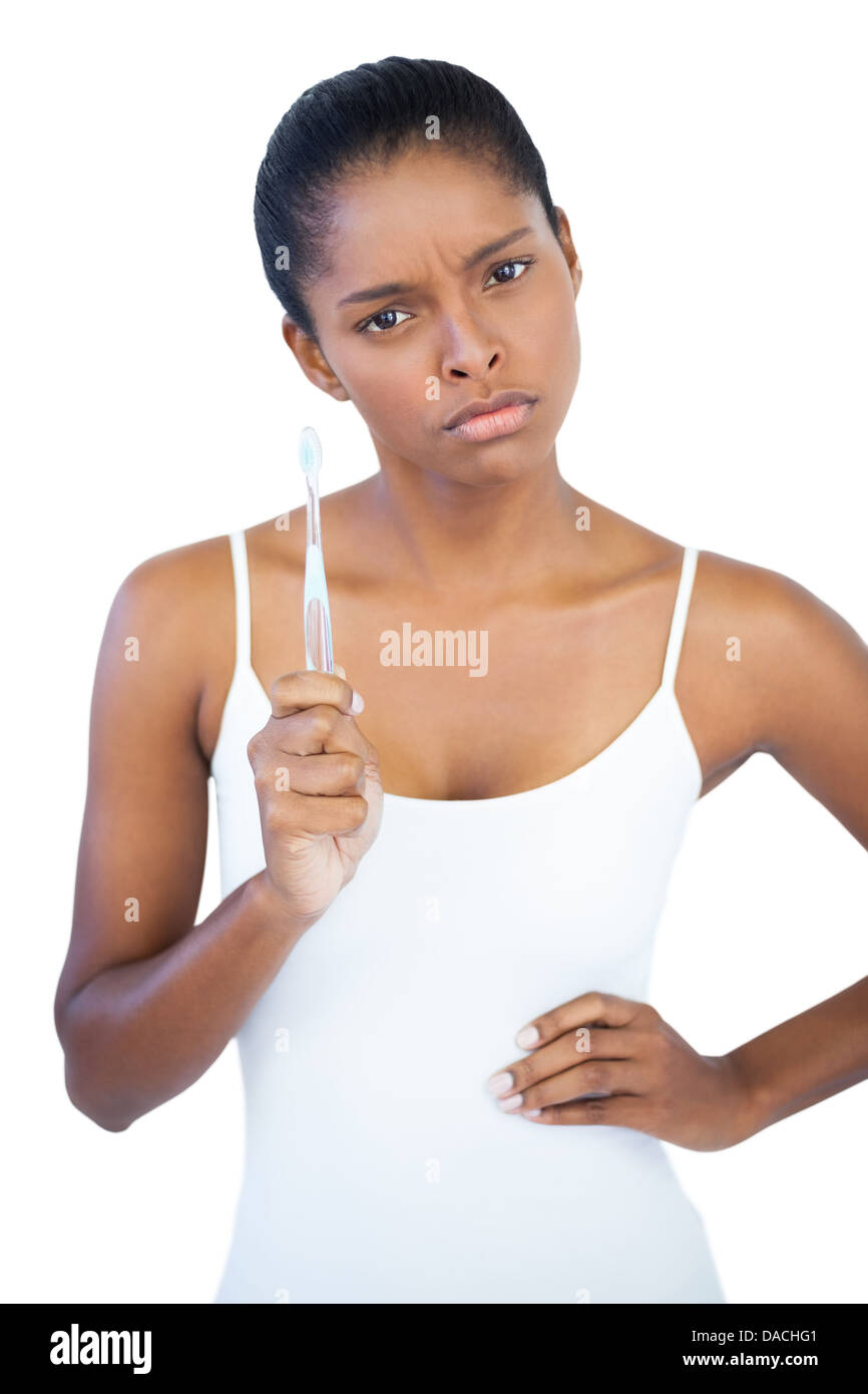 Schwere Frau mit der Hand auf der Hüfte halten ihre Zahnbürste Stockfoto