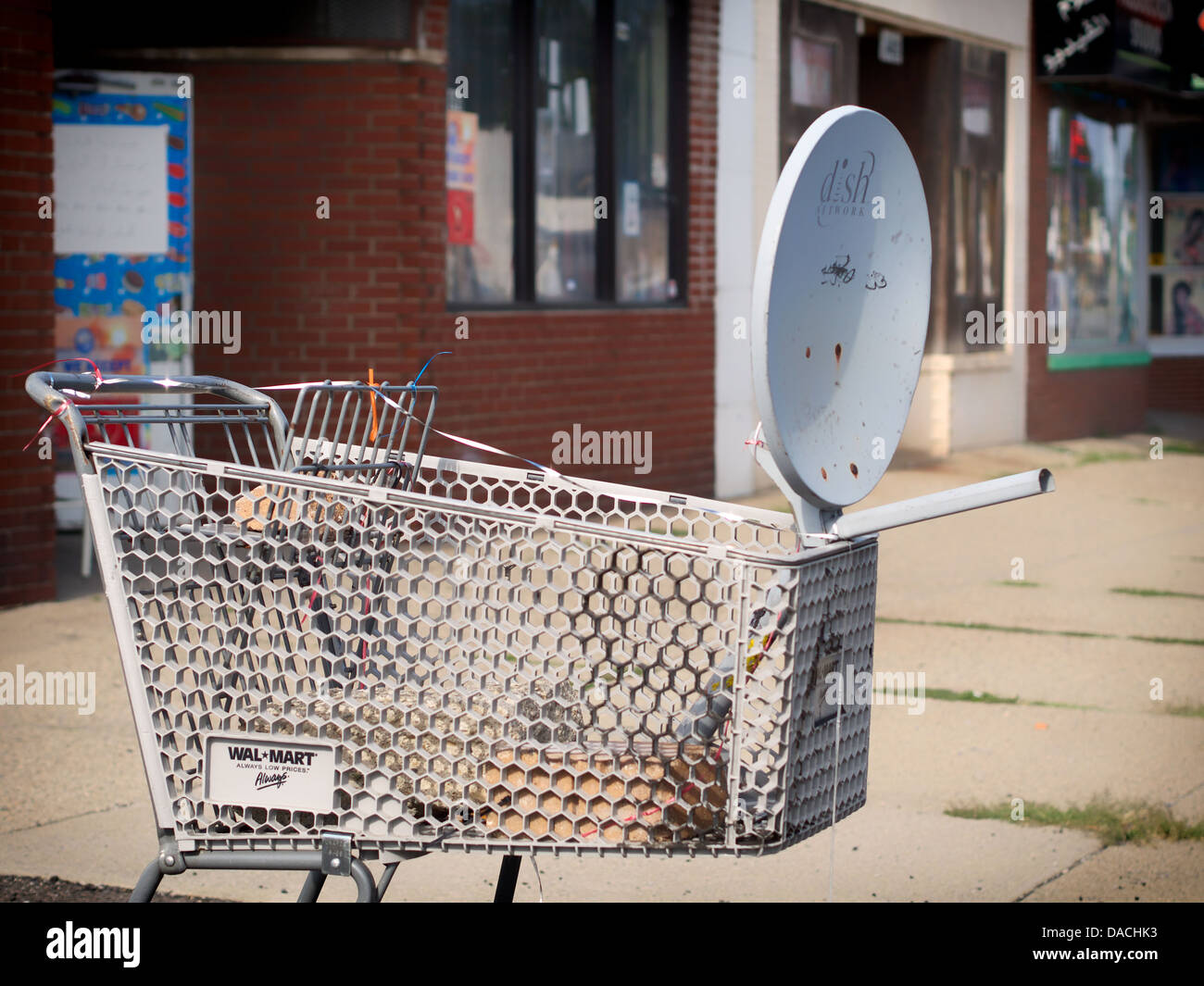 Satellitenschüssel angebracht zu einem aufgeschlüsselt Einkaufswagen außerhalb eines Ladens in Detroit. Stockfoto