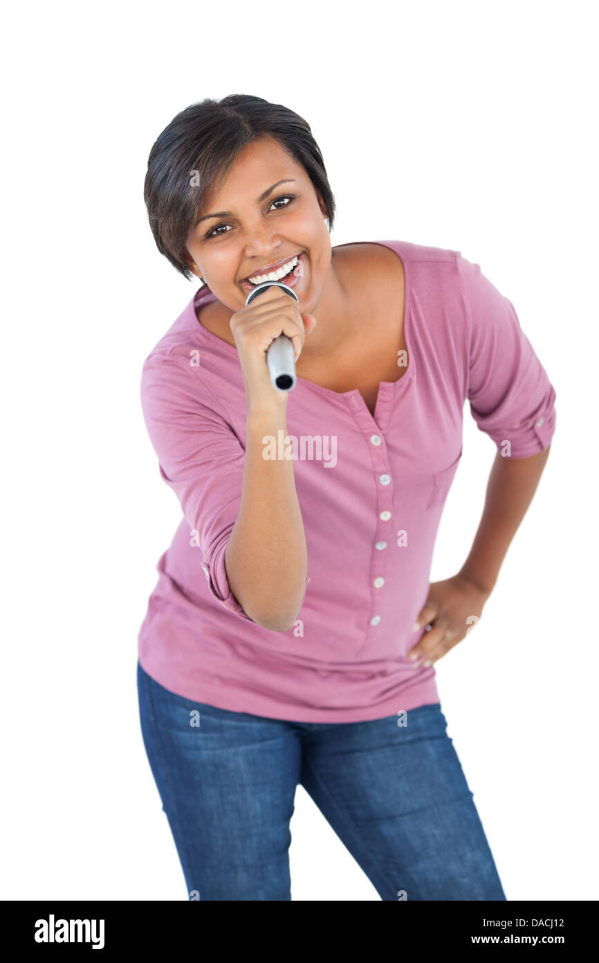 Lächelnde Frau hält Mikrofon für Gesang Stockfoto