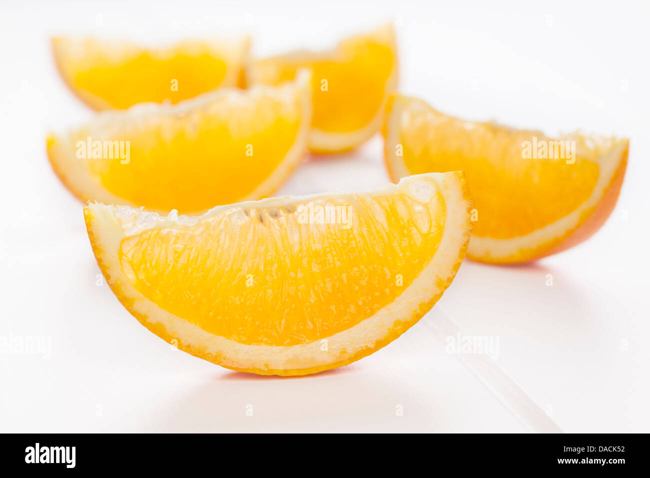 Orange Keile oder Scheiben auf einem weißen Hintergrund mit weichen Schatten. Stockfoto