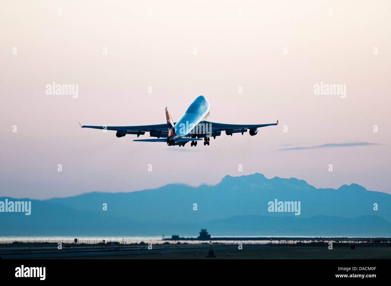 Eine British Airways Boeing 747-400 Widebody-Jumbo Jet Airliner fährt in der Abenddämmerung vom Vancouver International Airport. Stockfoto