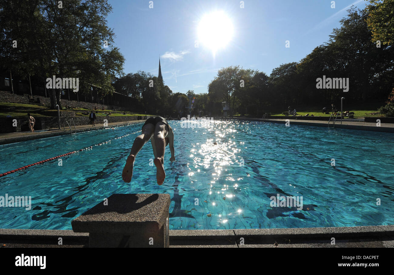 Ein Junge springt in ein Freibad in Hamburg, Deutschland, 29. September 2011. Deutschland erlebt warmes Wetter Ende September mit Temperaturen um die 23 Grad im Norden. Foto: Daniel Bockwoldt Stockfoto