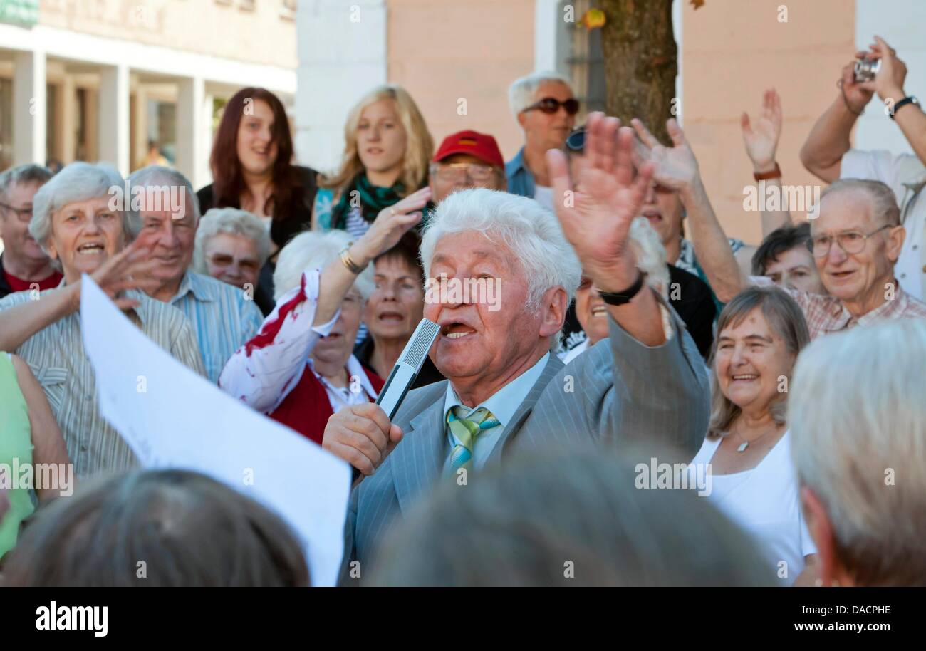 Chorleiter Gotthilf Fischer (C) steht umgeben von einer Menge singen Volkslieder auf dem Marktplatz in Eisenach, Deutschland, 30. September 2011. Die Veranstaltung markiert den Auftakt zu den im Fernsehen übertragenen live-Event "Die Schoensten Deutschen Volkslieder" (die schönsten deutschen Volkslieder) von deutschen Rundfunksender MDR, die den beliebtesten Song nominiert. Foto: Michael Reichel Stockfoto