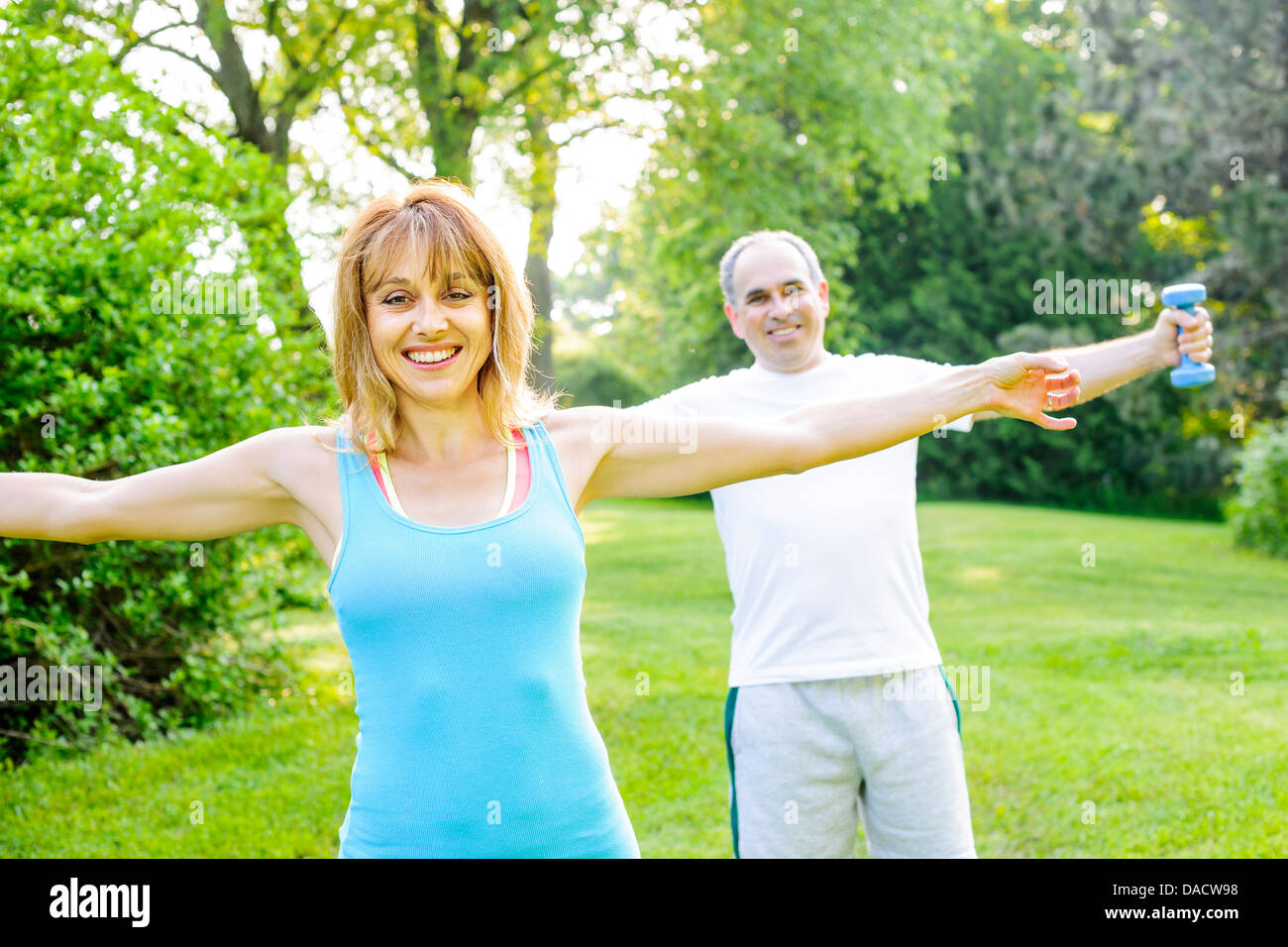 Weiblichen Fitness-Instruktor Training mit mittleren Alter Mann im Freien im Sommerpark Stockfoto