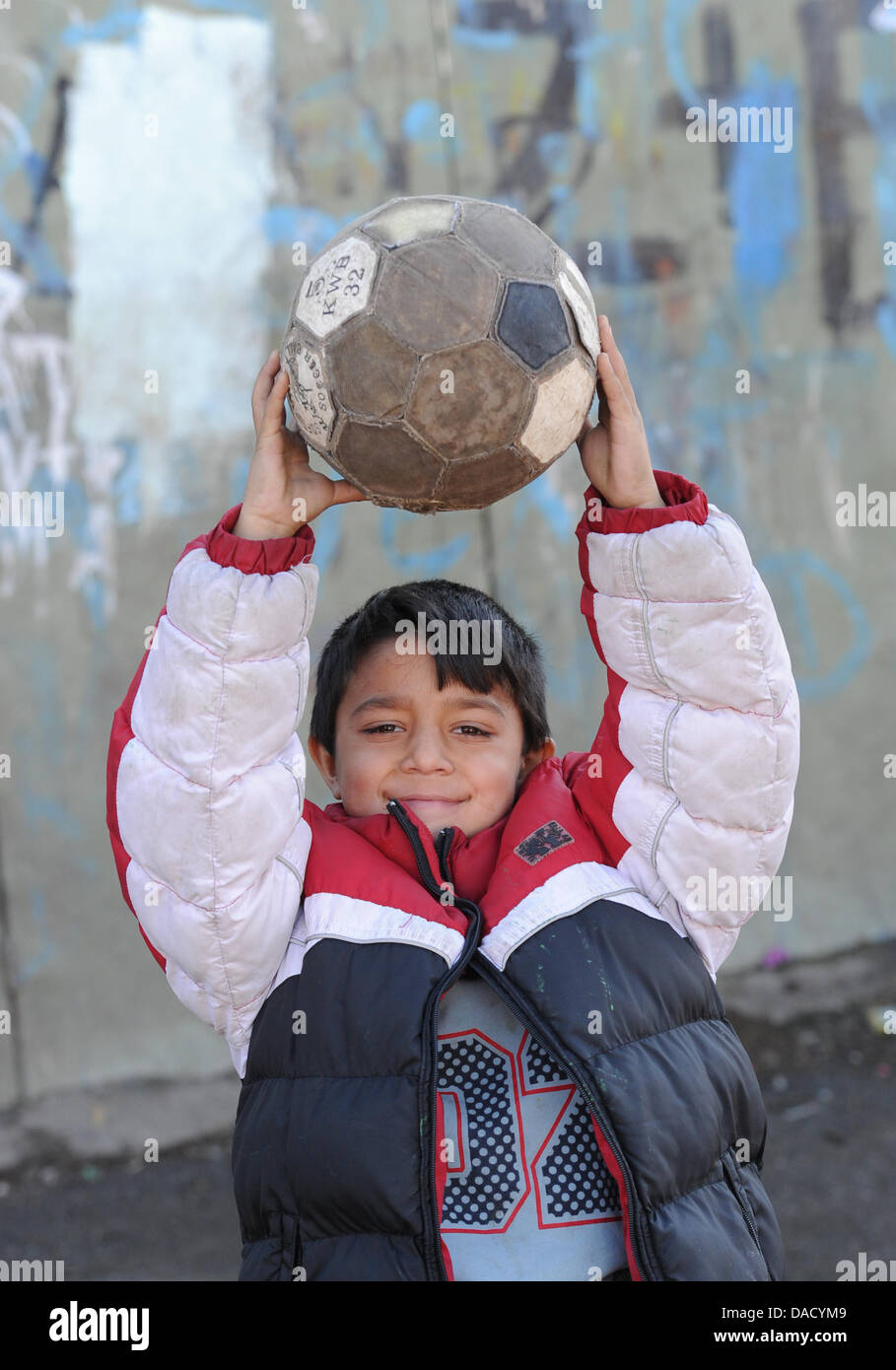 Ein junge Roma lächelt und präsentiert seine Fußball-Ball im Flüchtlingslager in Leposavic, Kosovo, 18. Dezember 2011. Roma-Familien aus Deutschland und anderen europäischen Ländern deportiert wurden Leben im Flüchtlingslager Blei kontaminiert, auf engstem Raum und mit schlechten hygienischen Bedingungen. Der United Nations International Children Emergency Fund UNICEF versucht mit medizinischen Treatm helfen Stockfoto