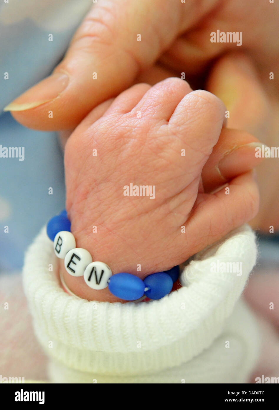 ILLUSTRATION - eine Armband mit dem Namen "Ben" schmückt die Hand eines zwei Tage alten Babys auf der Mutter-Kind-Station von Hannover Medical School (MHH) in Hannover, 29. Dezember 2011. Mit nur drei Buchstaben sind die Namen Mia und Ben die beliebtesten Namen für Neugeborene im Jahr 2011. Foto: Julian Stratenschulte Stockfoto