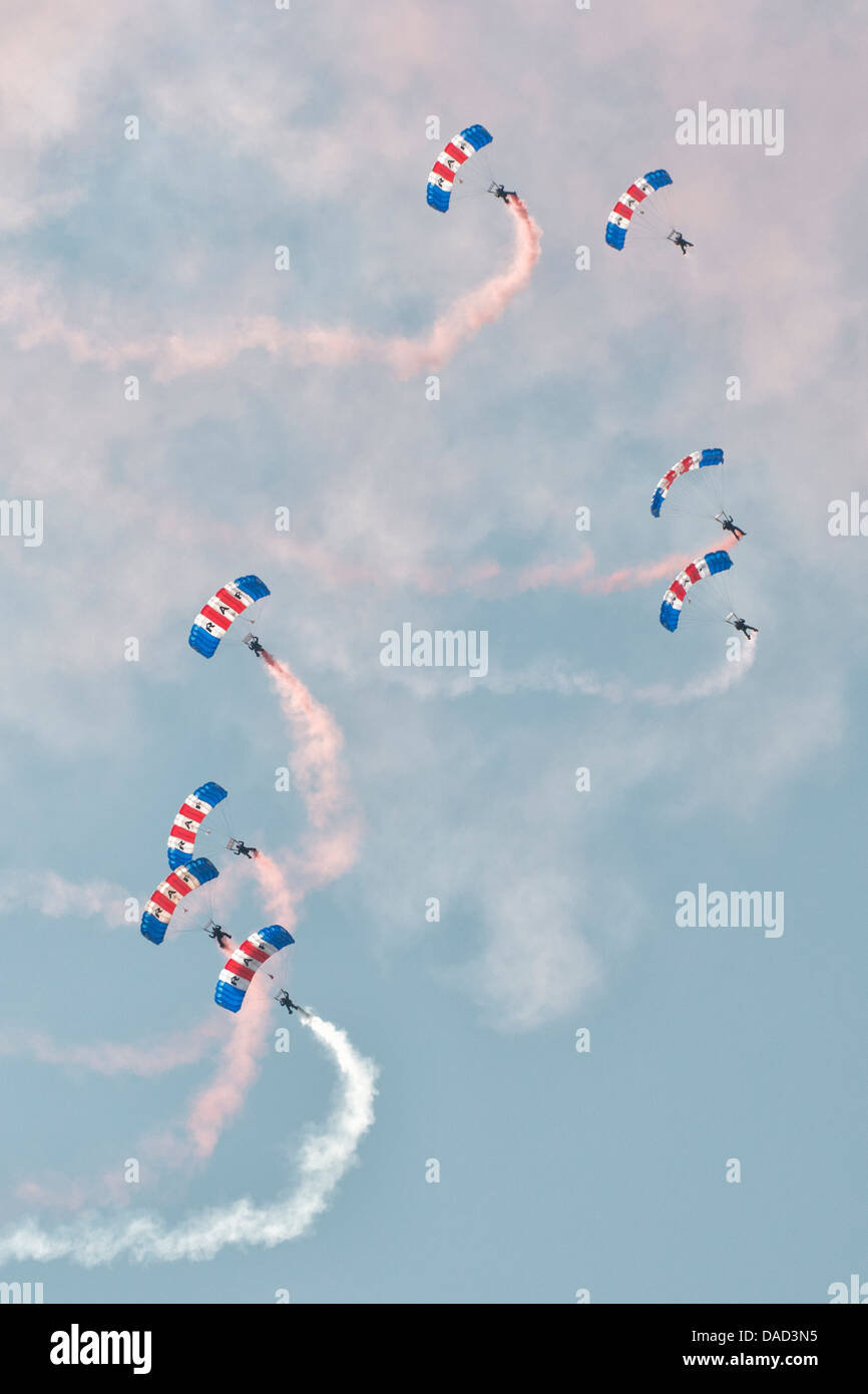 Fallschirmspringer aus der Royal Air Force Falcons anzeigen Team füllen den Himmel mit ihren bunten Fallschirm Verdecke und Rauch Wanderwege Stockfoto