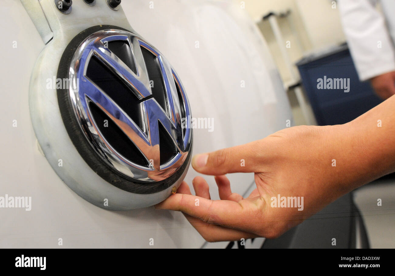 Ein Montagearbeiter klebt ein Volkswagen-Logo, ein Volkswagen Saveiro überqueren während seines Besuchs in das Volkswagen-Werk Anchieta in Sao Bernardo Compo in der Nähe von Sao Paulo, Brasilien, 4. Oktober 2011. VW ist 3,4 Milliarden Euro in seine brasilianische Montagewerk bis 2016 zu investieren. Foto: Julian Stratenschulte Stockfoto