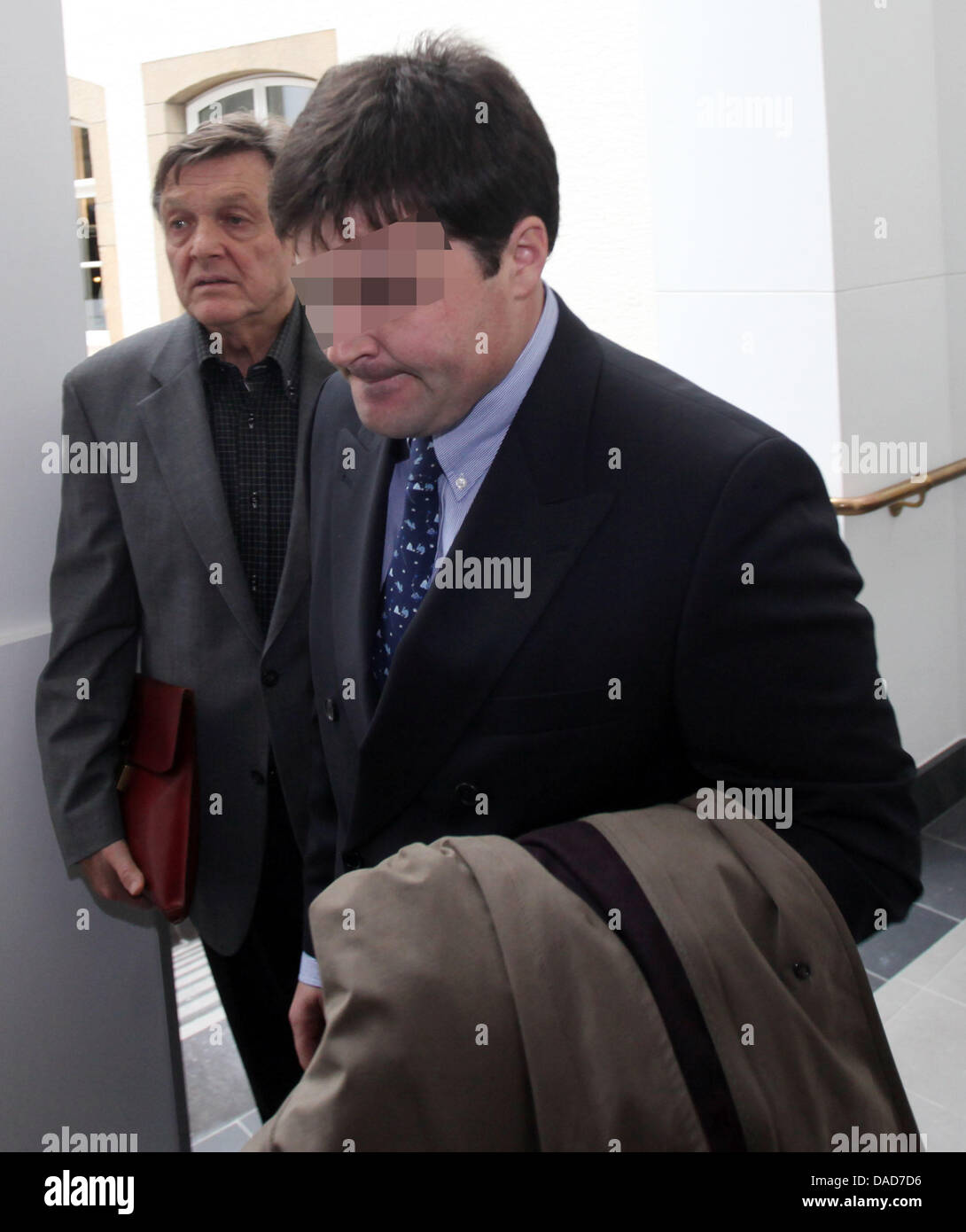 Der Flugkapitän das propellergetriebene Flugzeug (Name unbekannt) kommt in den Gerichtssaal des Landgerichts in Luxemburg, 10. Oktober 2011. Die Verhandlung über einen Unfall mit einem propellergetriebene Flugzeug von Luxair beginnt bei diesem Gericht am Nachmittag: auf 2. November 2002 das Flugzeug stürzte während der Landung auf dem Flughafen in Luxemburg. 20 Menschen starben bei dem Unfall Stockfoto