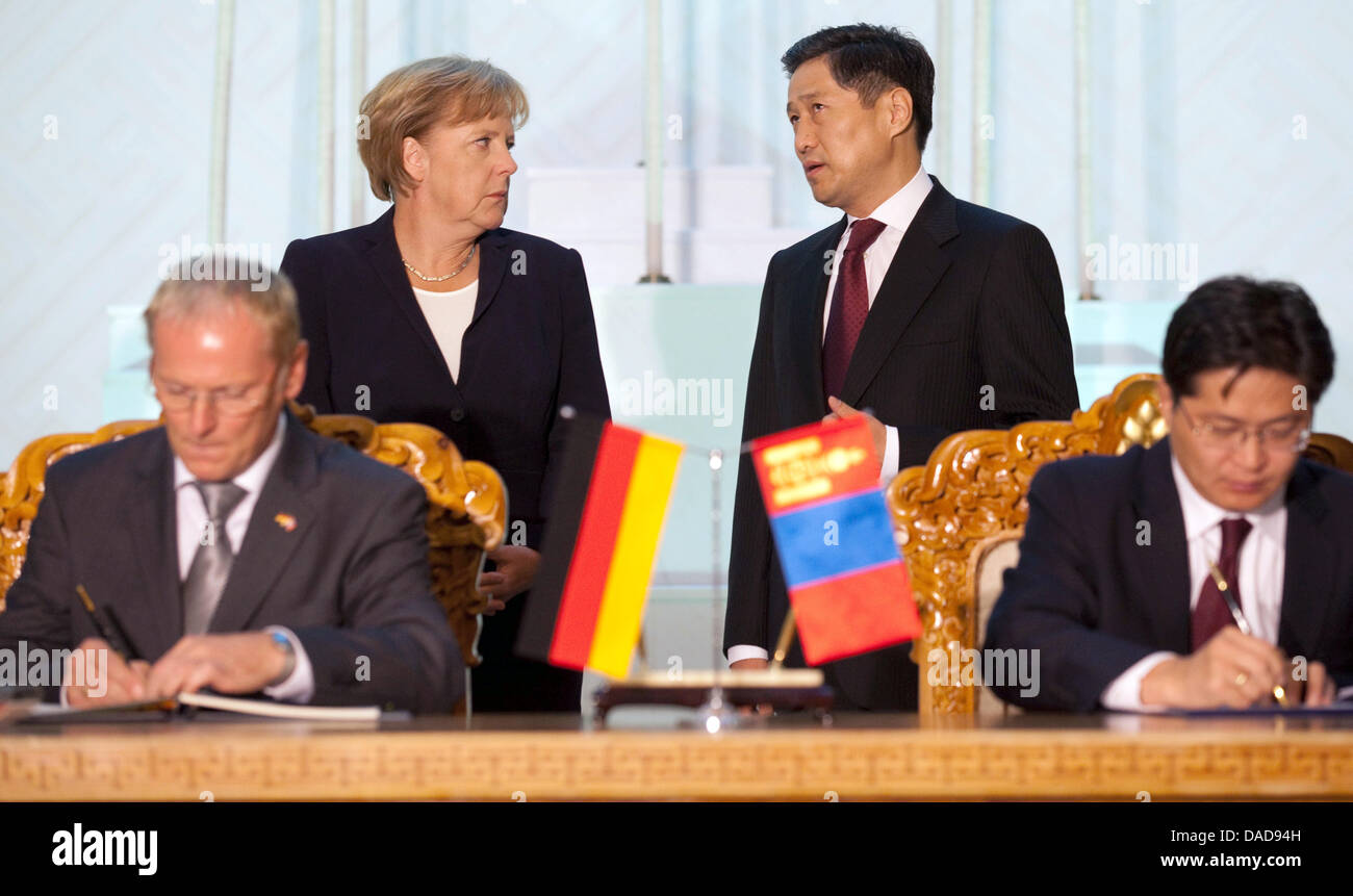 Bundeskanzlerin Angela Merkel (Rücken-L) spricht mit Ministerpräsident Sukhbaataryn Batbold (Rücken-R), während Verträge in Ulan Bator, Mongolei, 13. Oktober 2011 unterzeichnet werden. Merkel will auf ihrer Reise in die Mongolei Wirtschaftsabkommen abschließen. Foto: Michael Kappeler Stockfoto